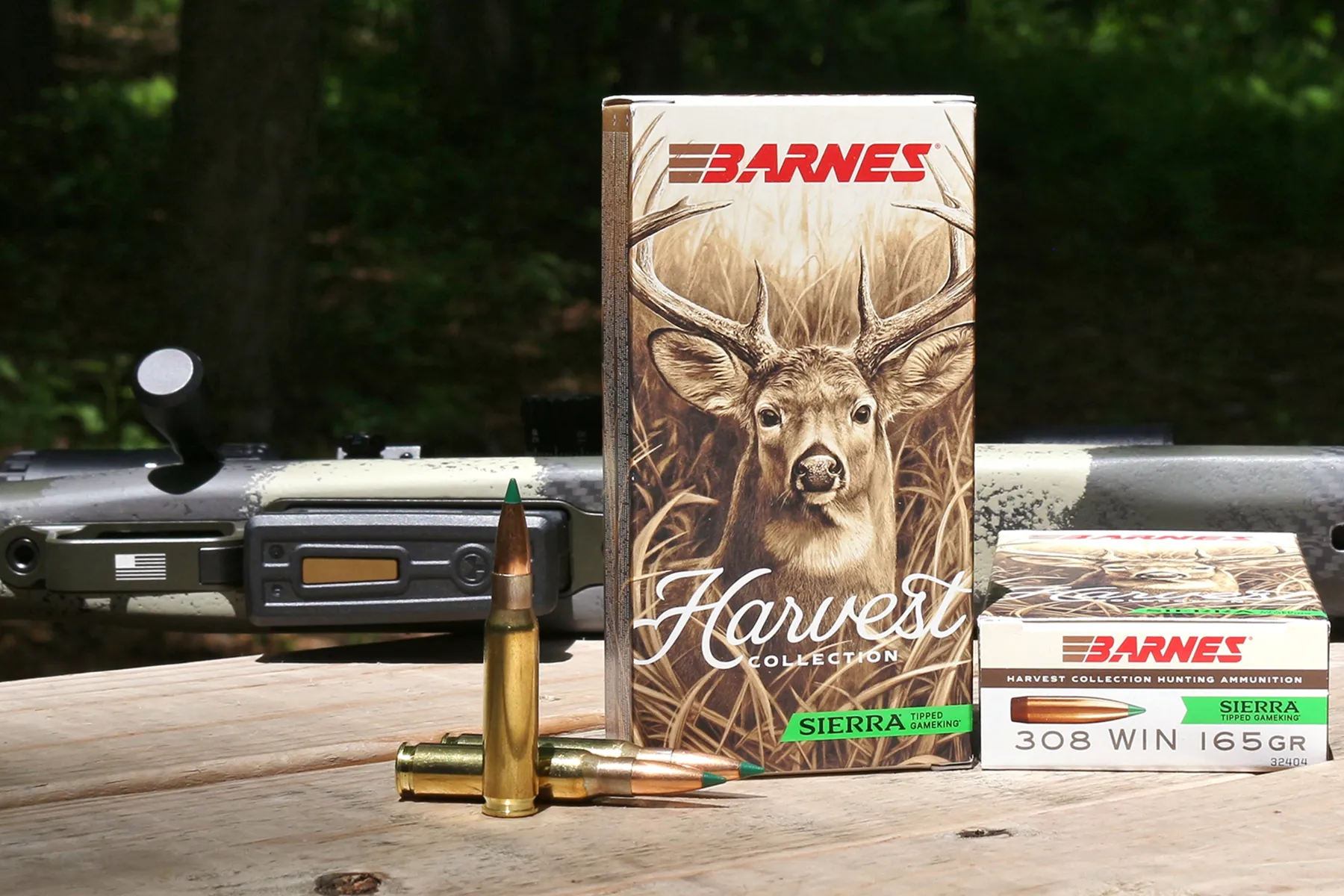 a box of Barnes Sierra Harvest Collection hunting ammo on a table with a rifle and looss cartridges in .308 Win
