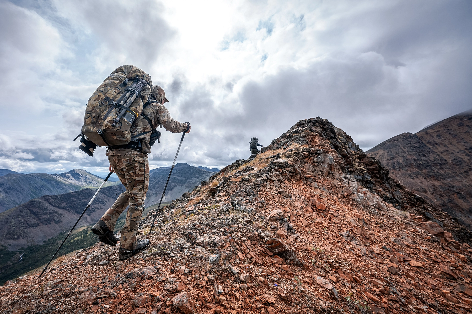 A hunter in KUIU camo walks the spine of a ridge