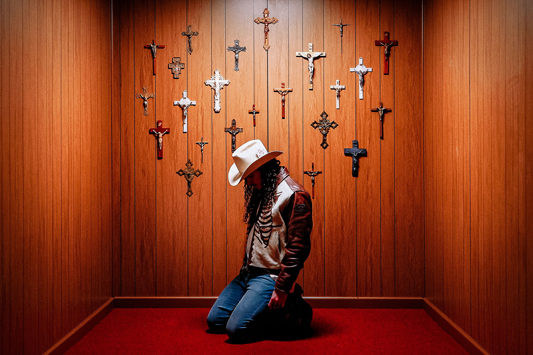 Brandon Lake kneeling in a room of crucifixes