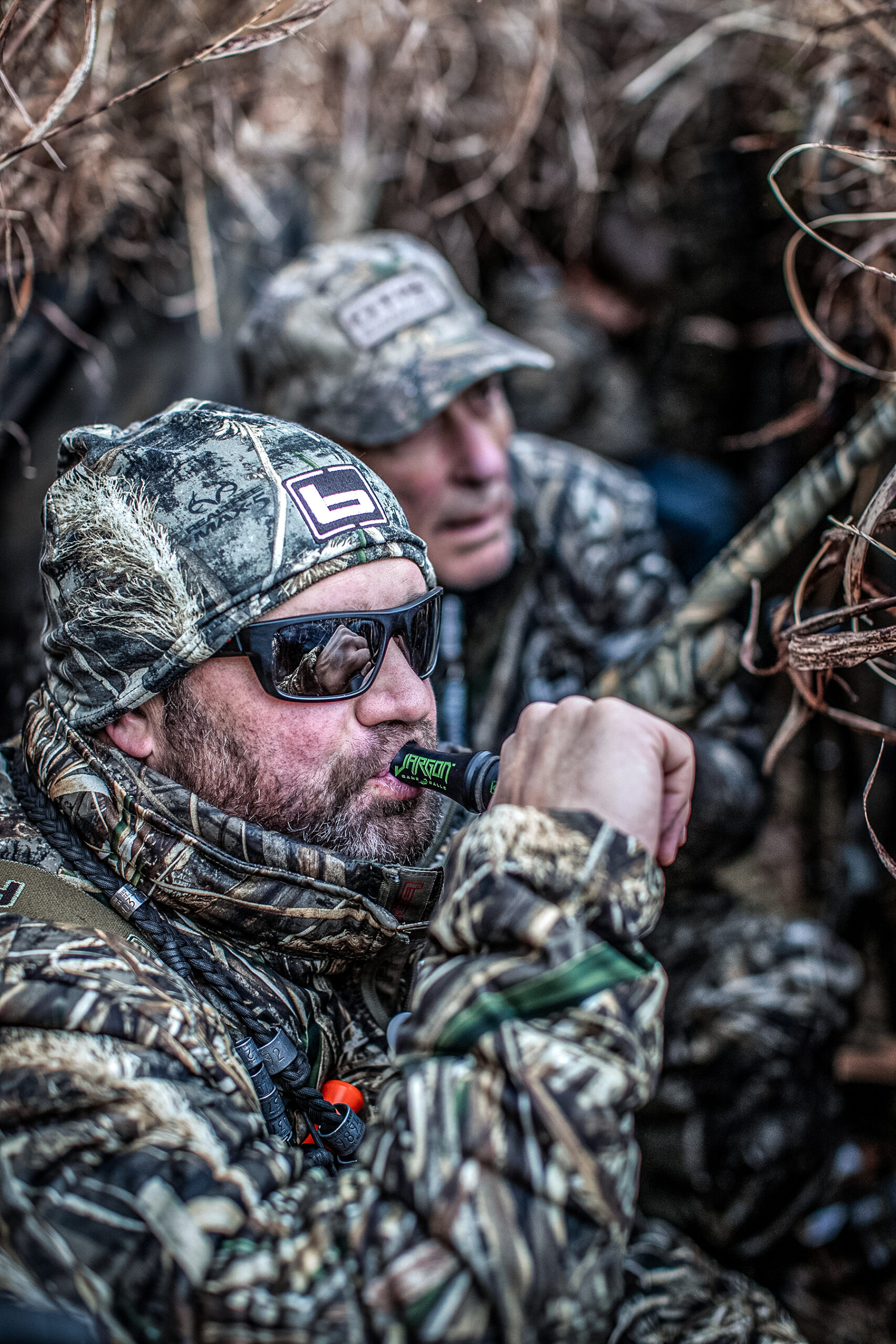 chad belding working a duck call in a blind