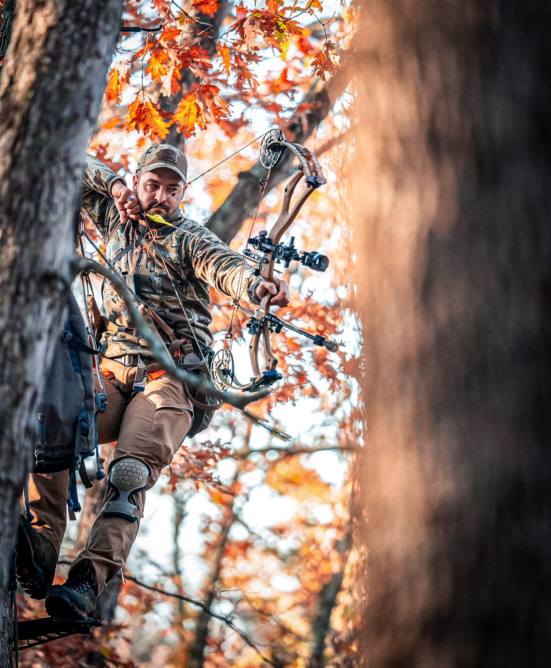 a bowhunter in a hunting saddle at full draw