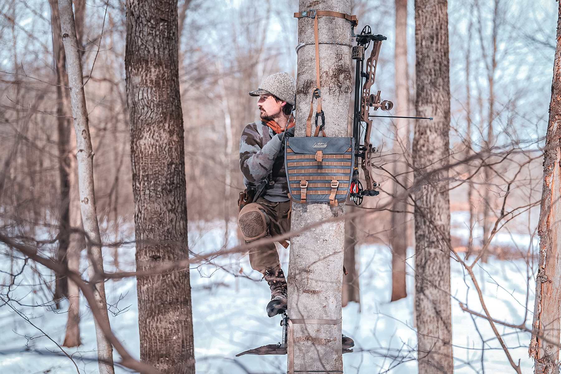a bowhunter in a hunting saddle on a tree
