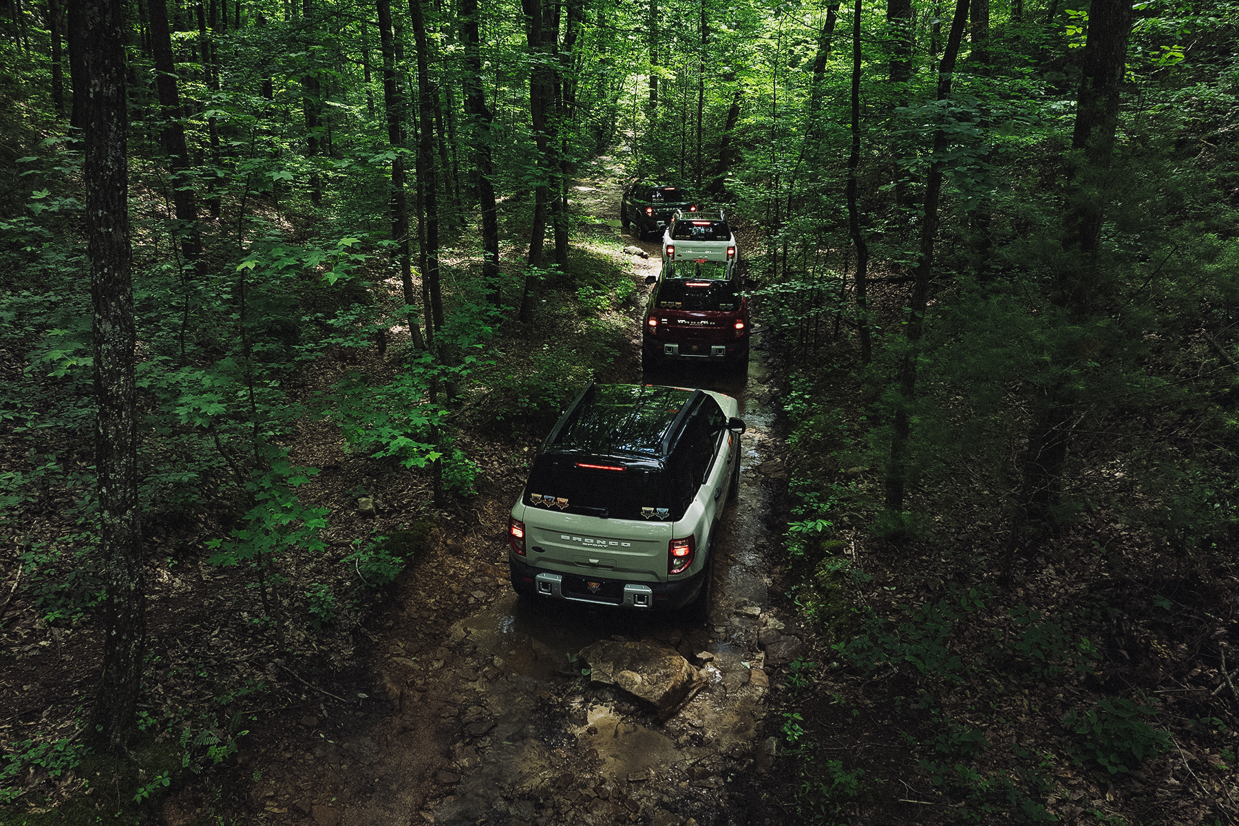 Ford Broncos driving off road on the Off-Roadeo course