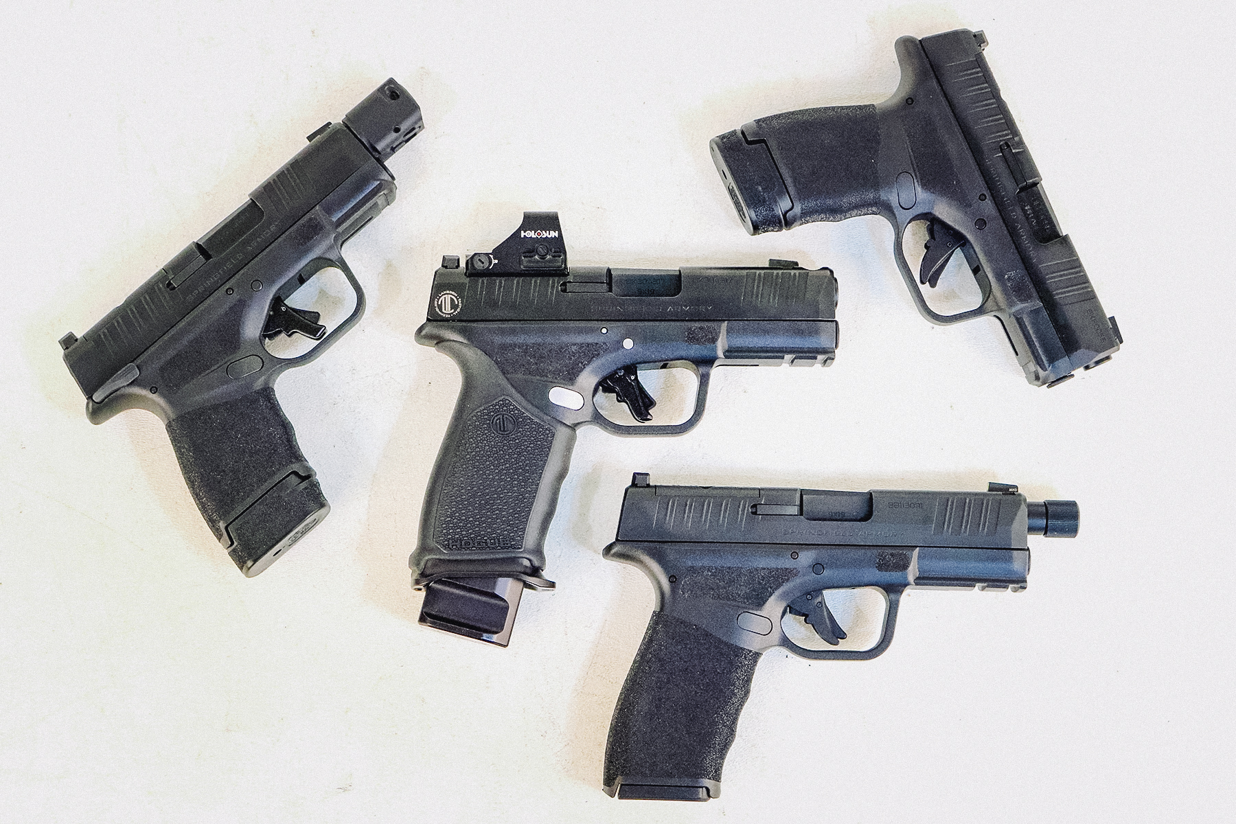 LTT Hellcat Pro with red dot with standard Hellcat, a Hellcat with a compensator, and a Hellcat Pro with a threaded barrel.