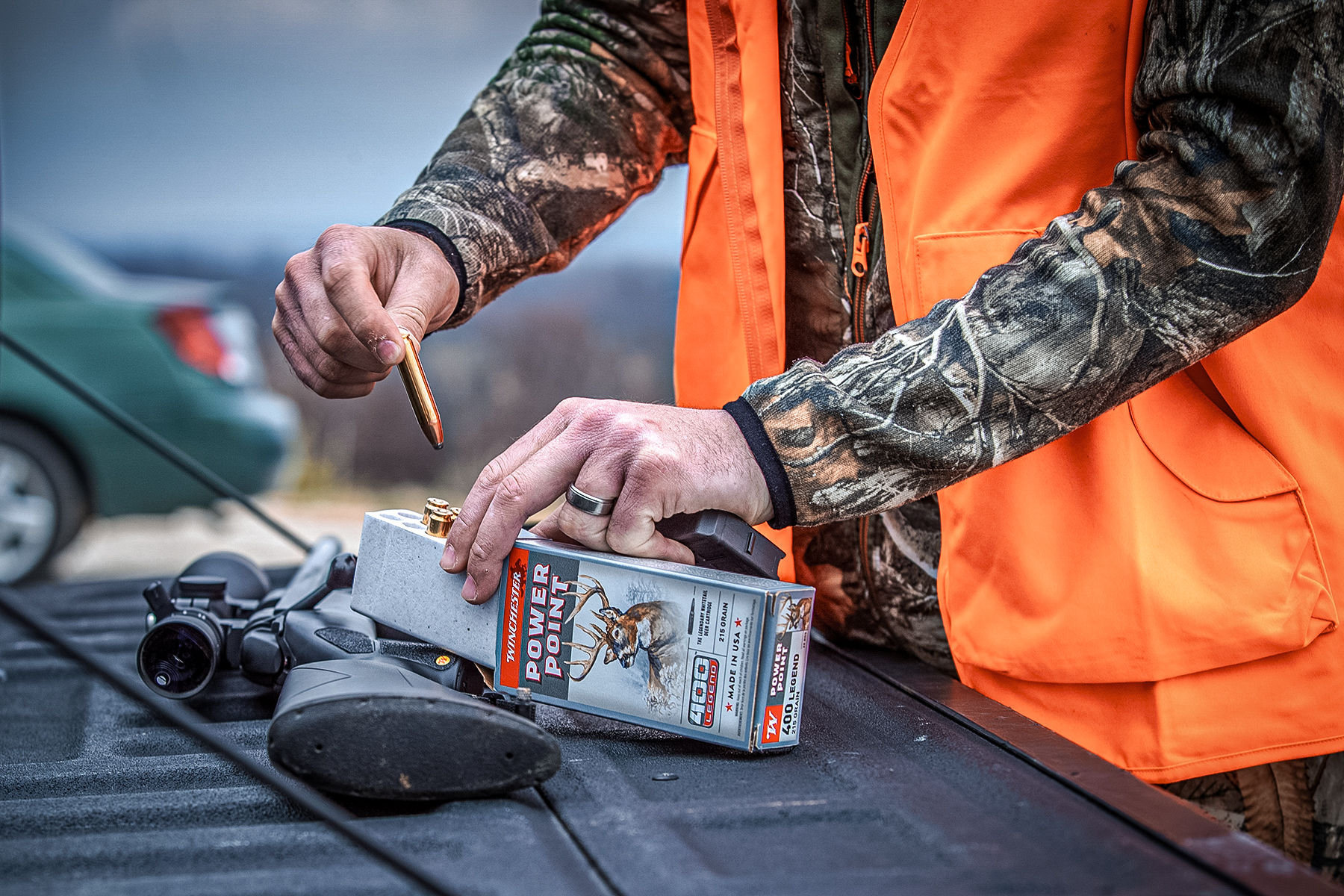 a hunter loading a magazine with 400 Legend cartridges on a tailgate