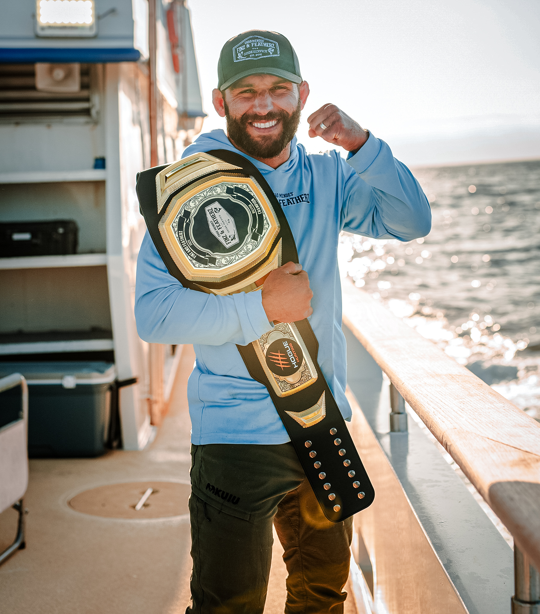 Chad Mendes with a championship belt on a boat