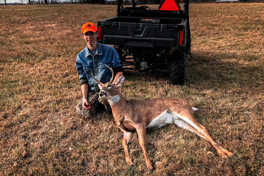 a hunter with a small whitetail buck