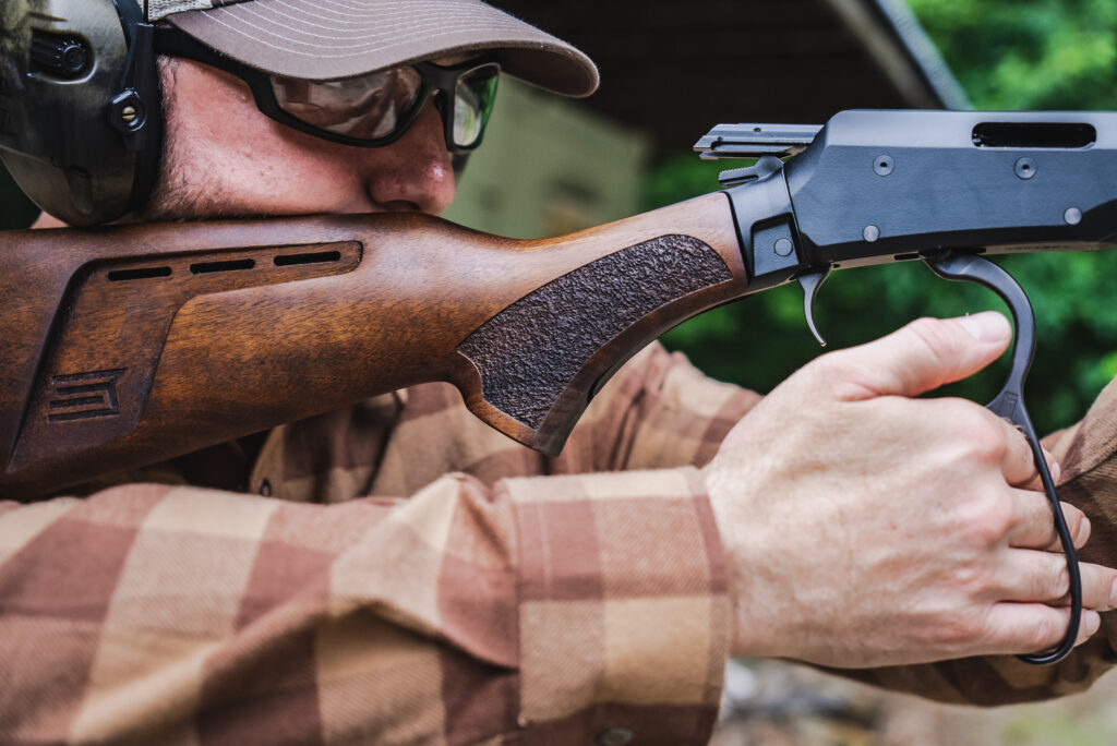 A man shoulders the Savage REVEL DLX rimfore lever action.