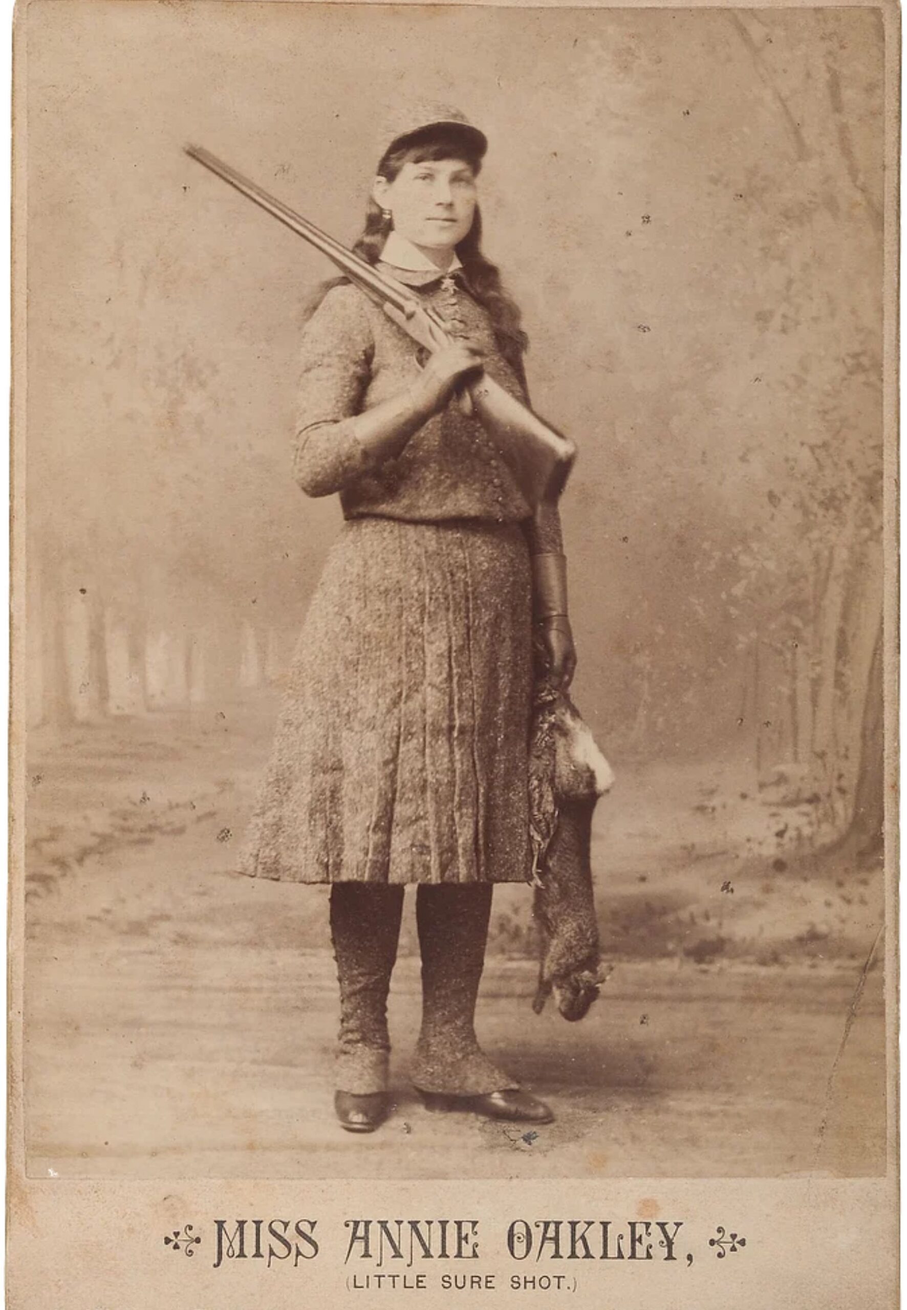 Annie Oakley with a shotgun and a rabbit
