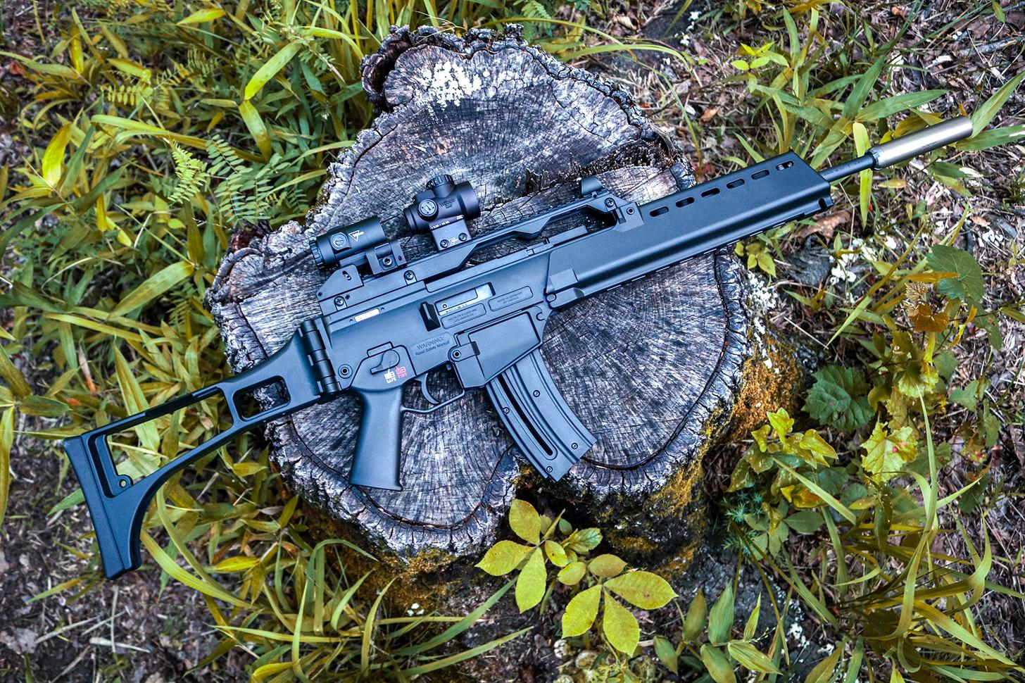 HK G36 Rimfire topped with a Trijicon red dot and magnifier and outfitted with a suppressor