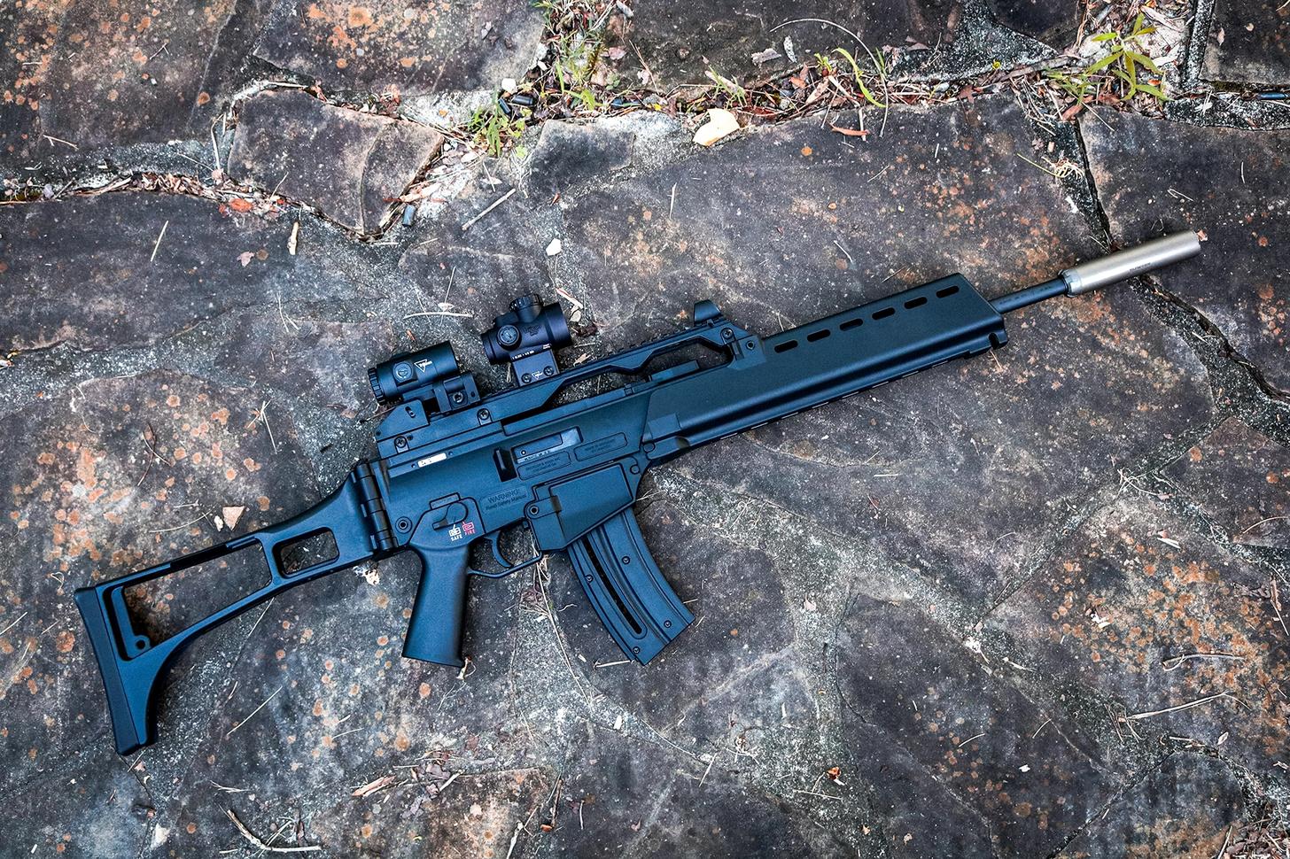HK G36 Rimfire topped with a Trijicon red dot and magnifier and outfitted with a suppressor