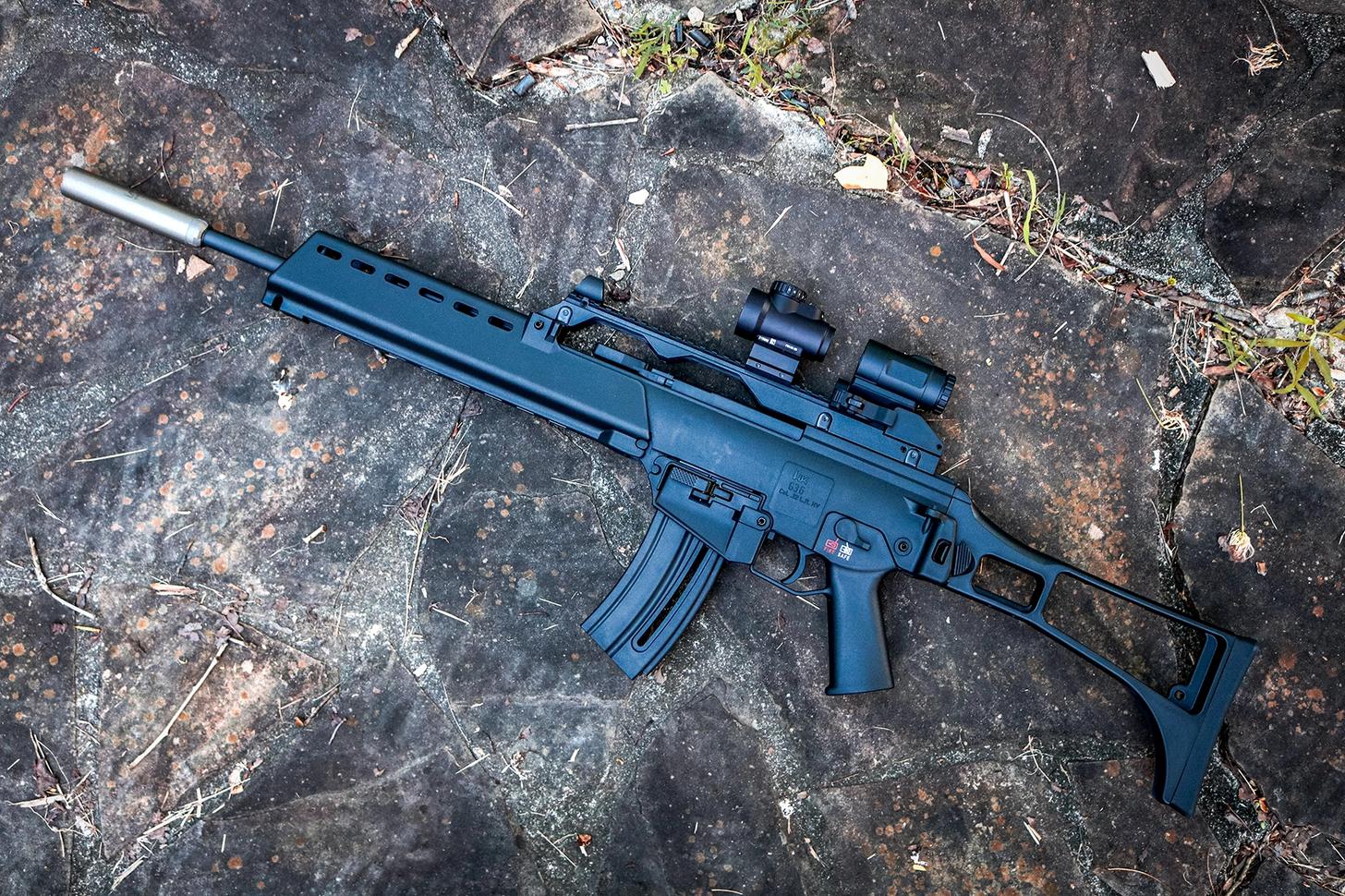 HK G36 Rimfire topped with a Trijicon red dot and magnifier and outfitted with a suppressor