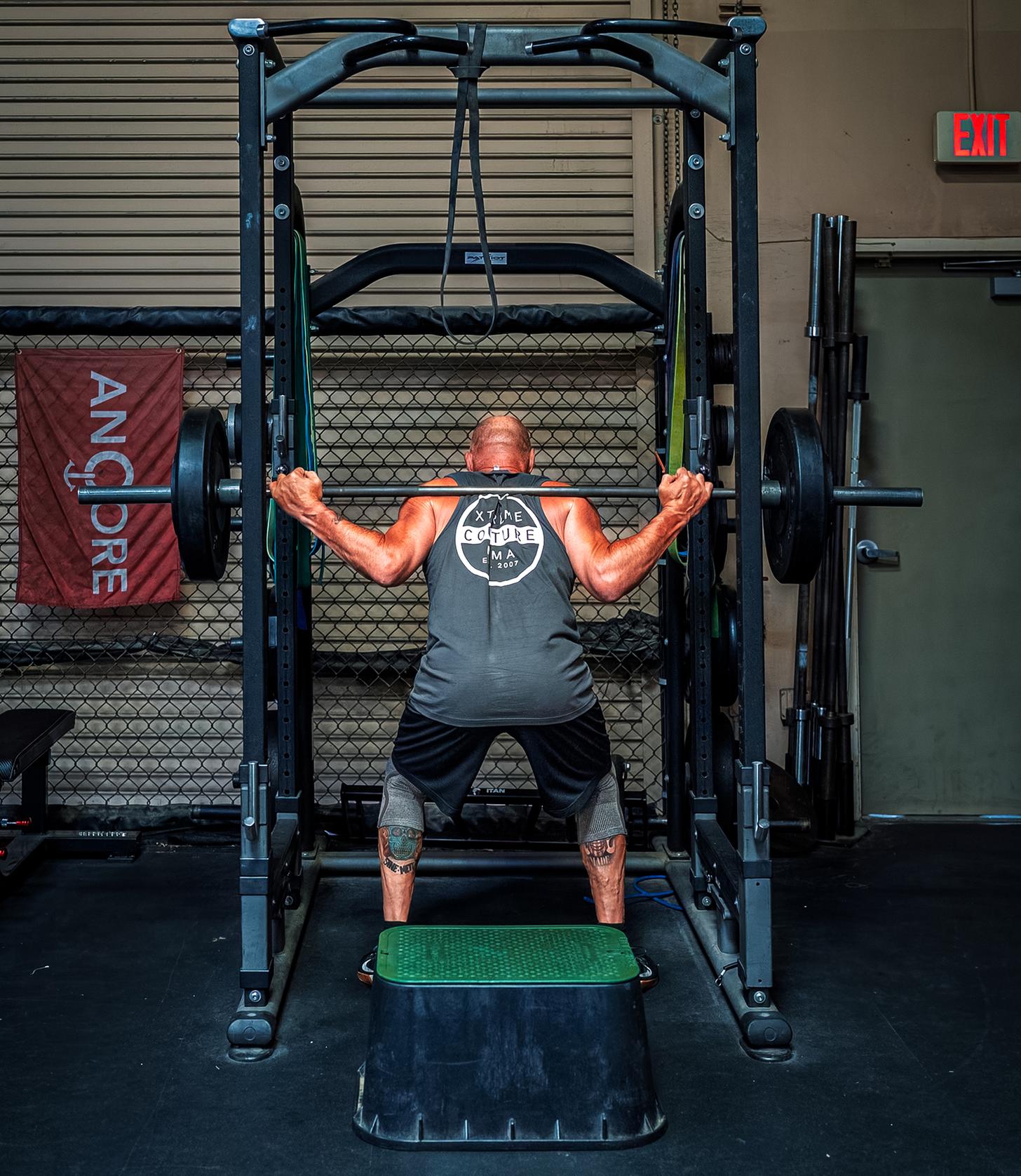 Randy Couture doing squats in a squat rack
