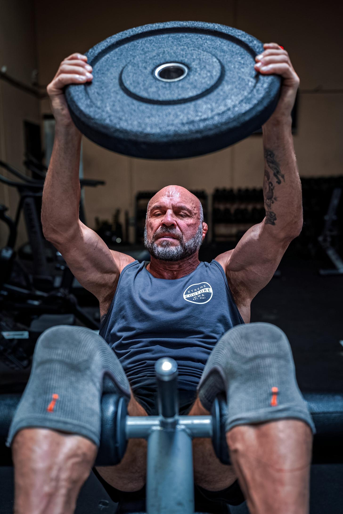 Randy Couture doing situps holdin a plate