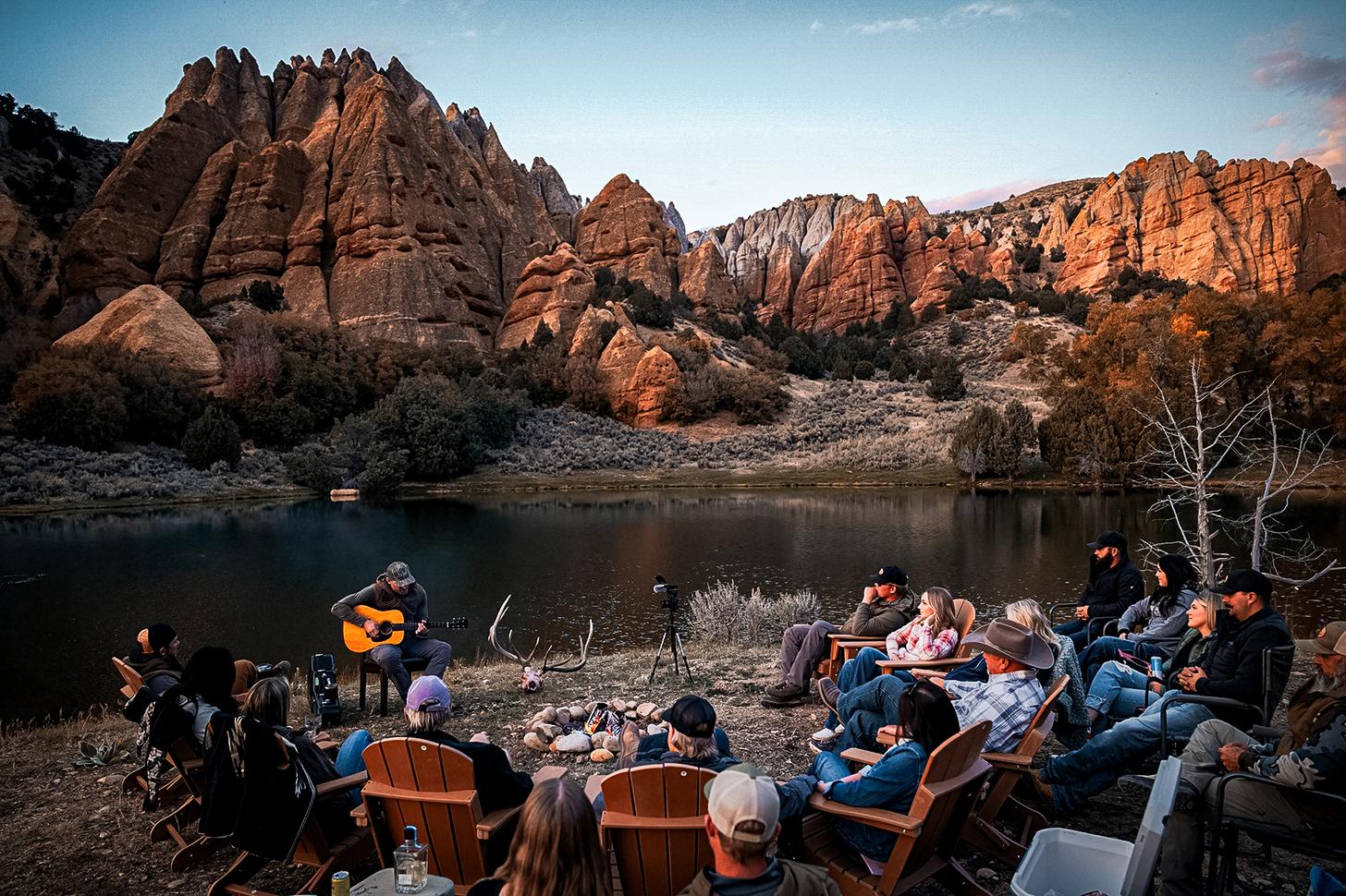 chase rice playing guitar with a circle of people