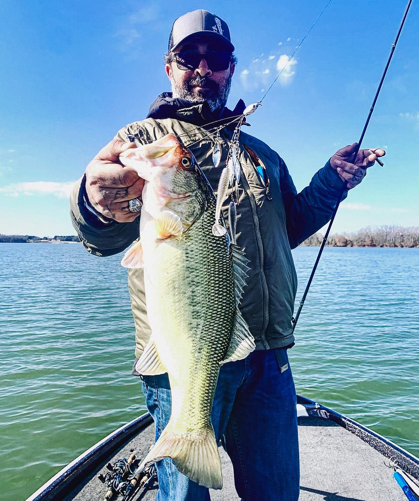 Aaron Lewis on a boat holding up a bass