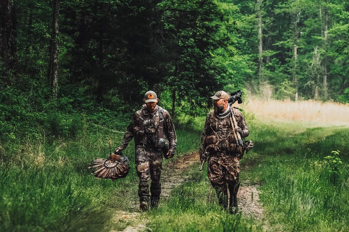 two turkey hunters walking a trail