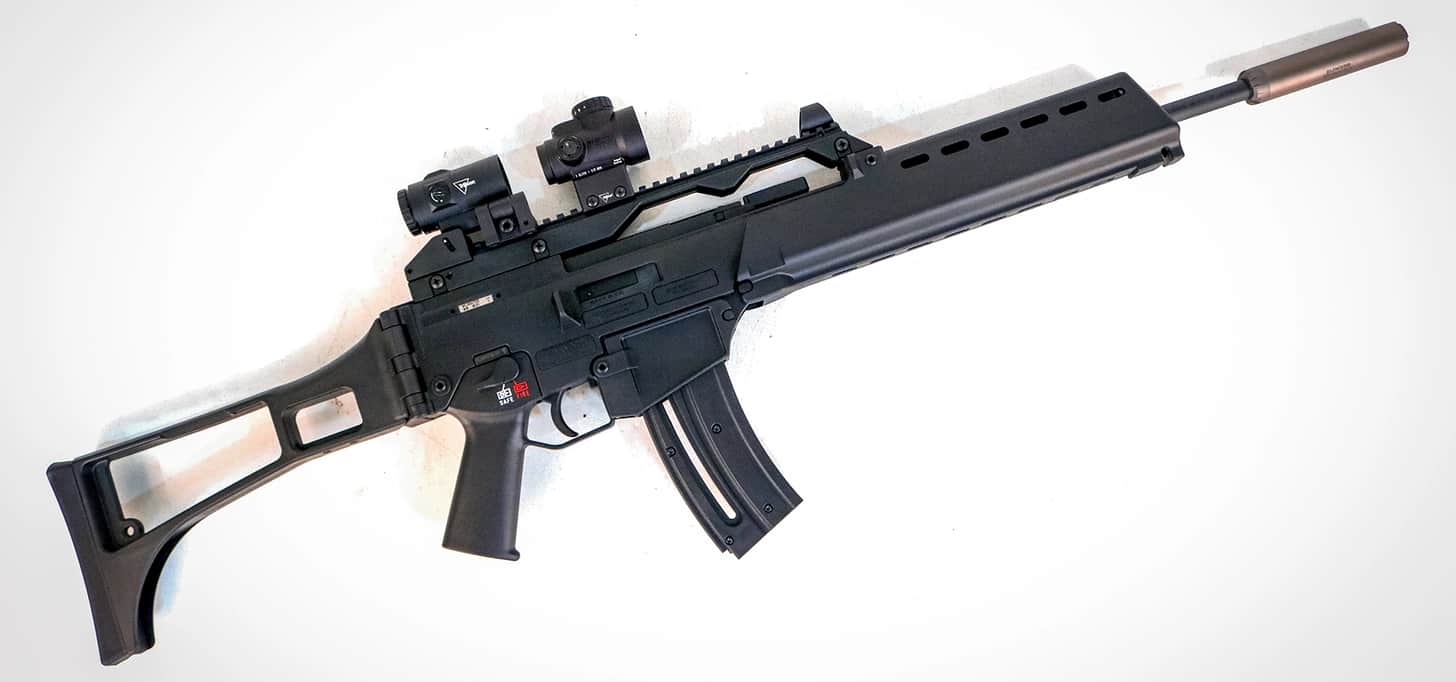 the rifle topped with a Trijicon red dot and magnifier