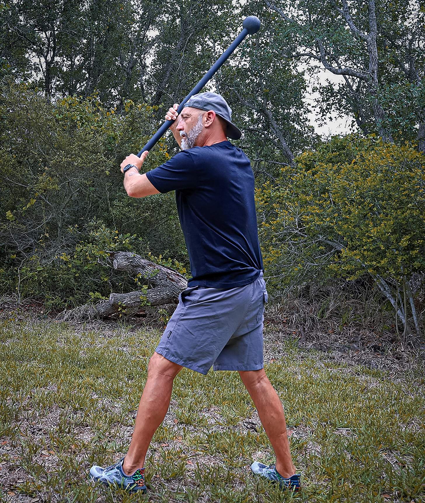 a man doing axe chops with a mace to simulate casting long rods as part of a fishing workout
