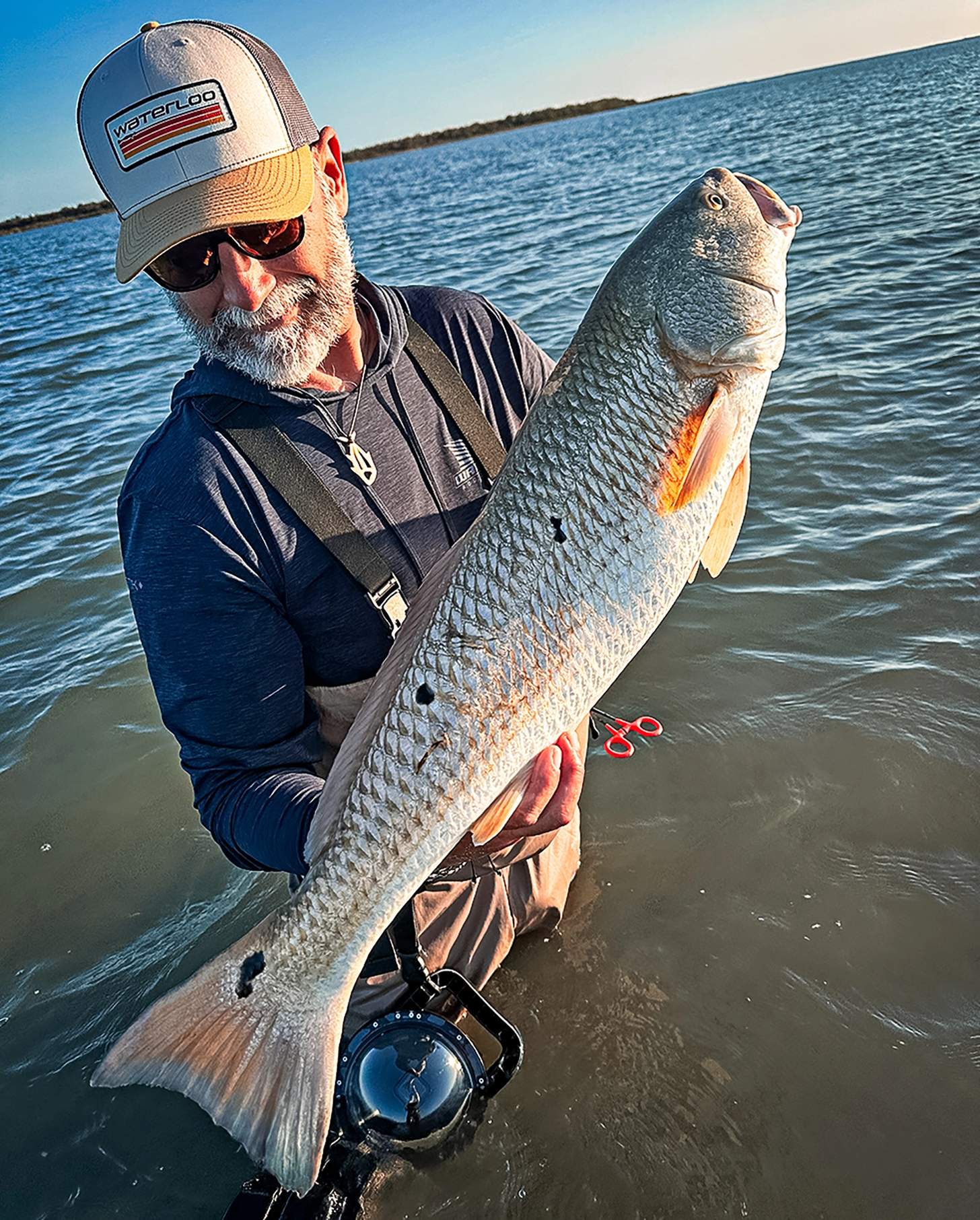 a surf angler with a fish - when you prep for a trip with a fishing workout, you suceed