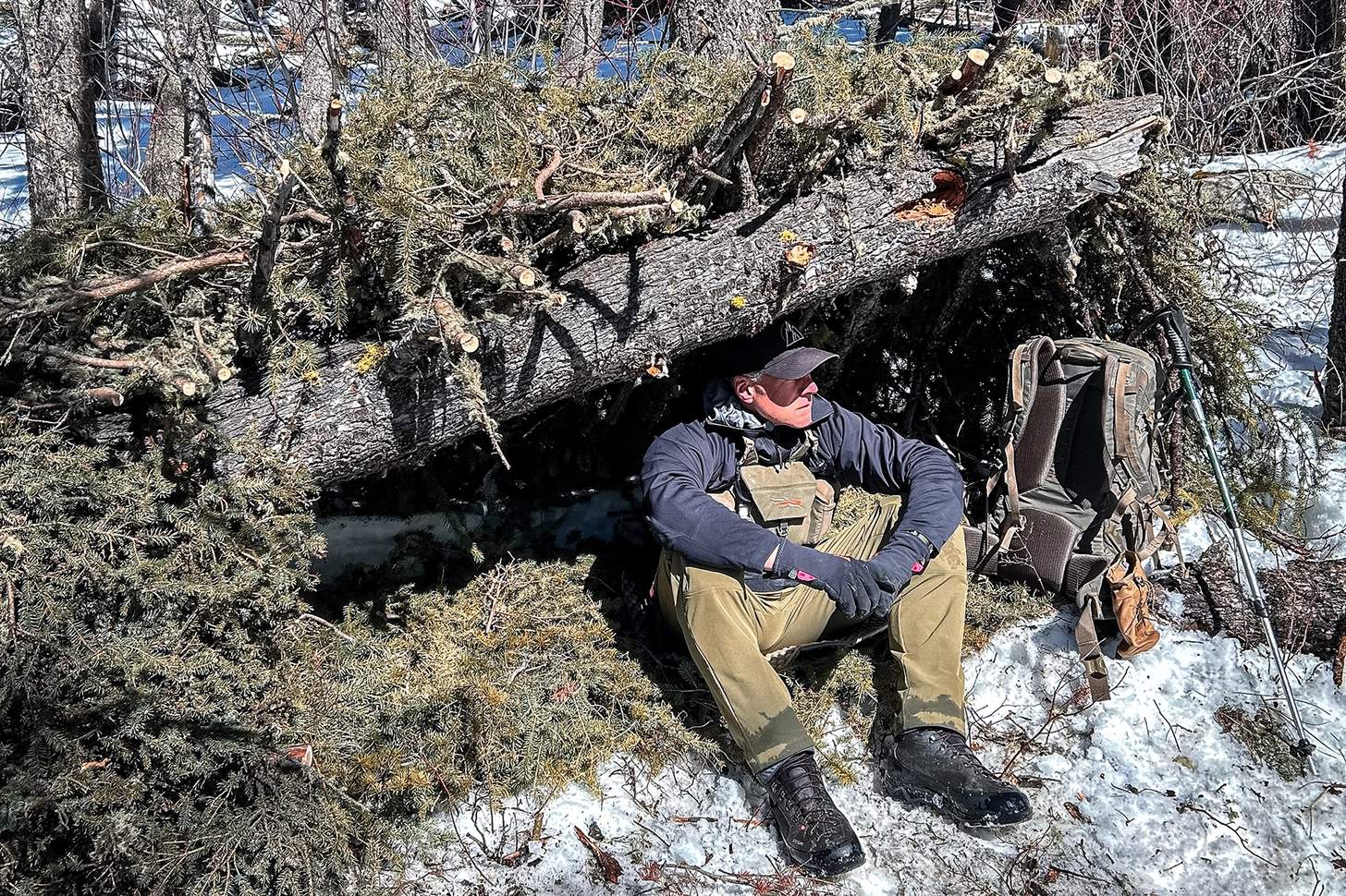 John Barklow sitting in a primitive shelter.
