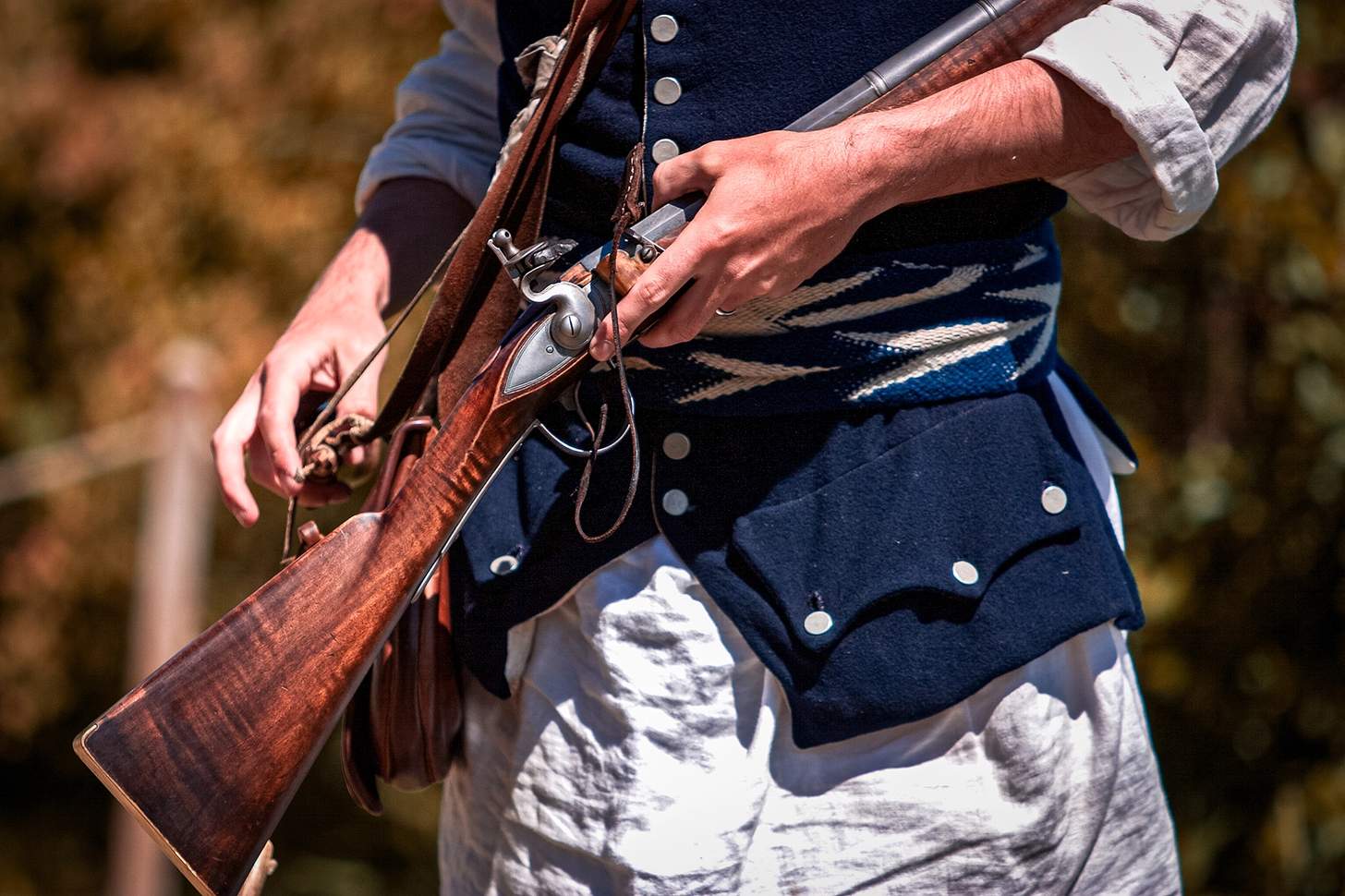 closeup of a flintlock held by a reenactor