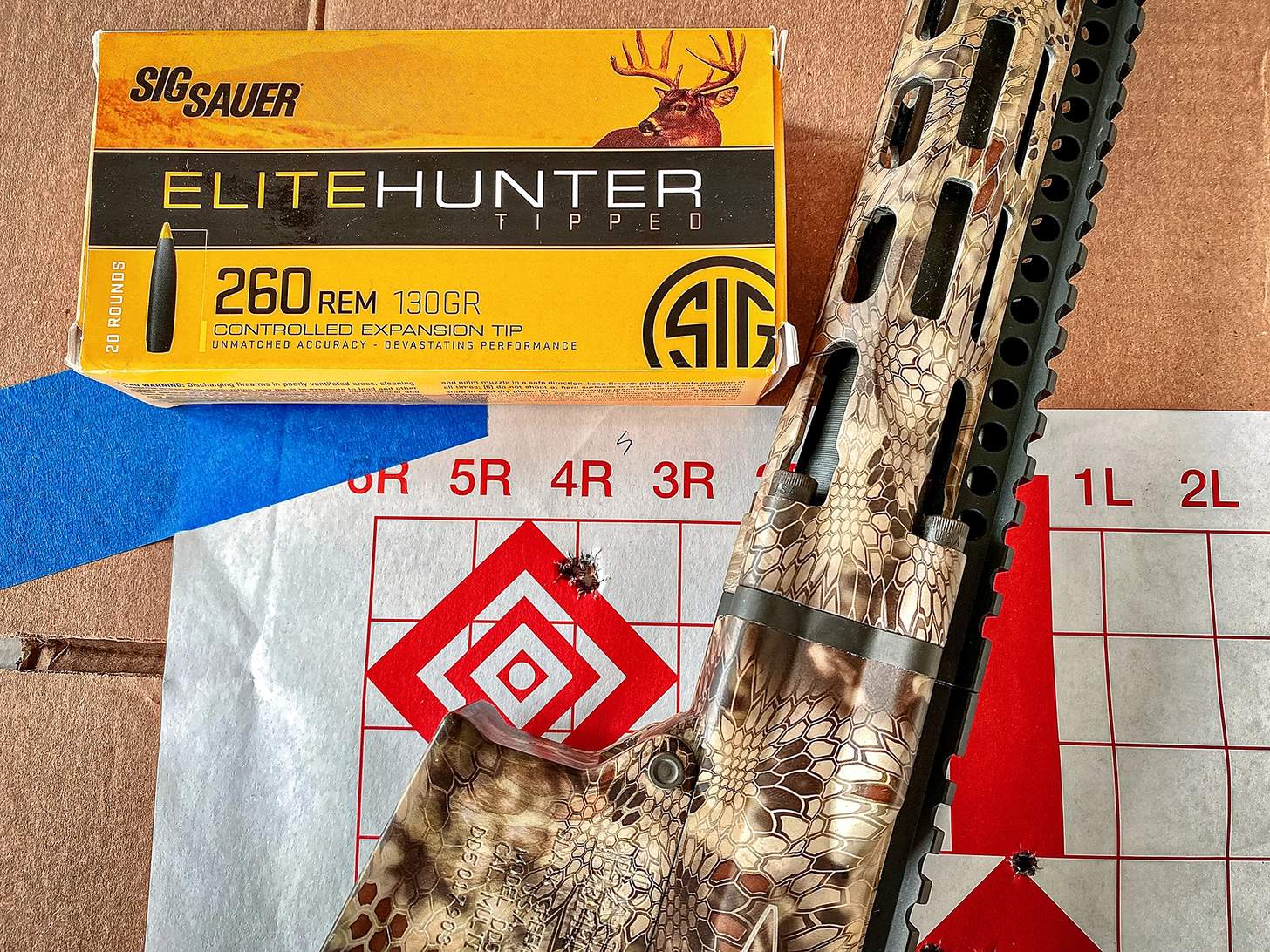 Daniel Defense DD5 V5 Hunter rifle with target and box of SIG SAUER Elite Hunter topped ammo in 260 rem
