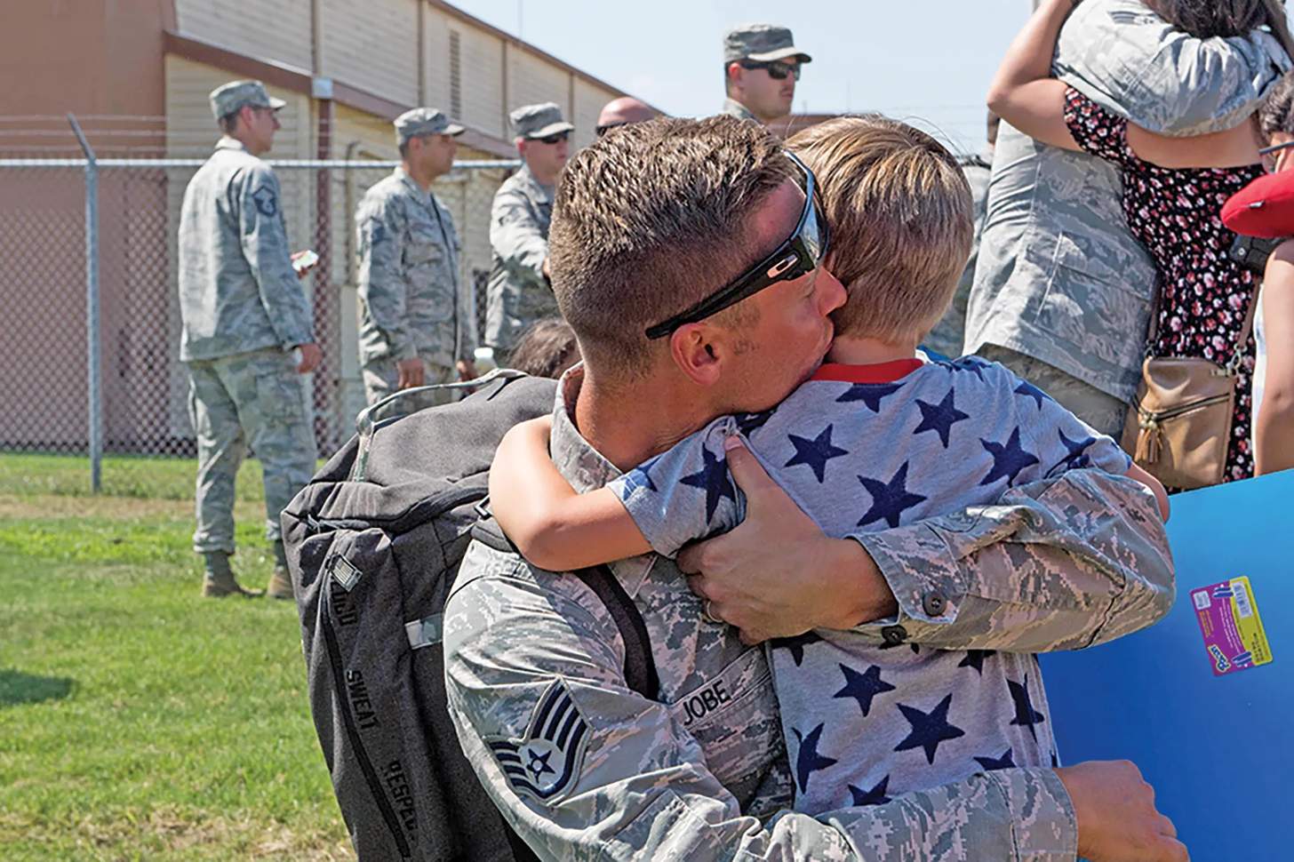 A returning U.S. Airman hugs his son. 
