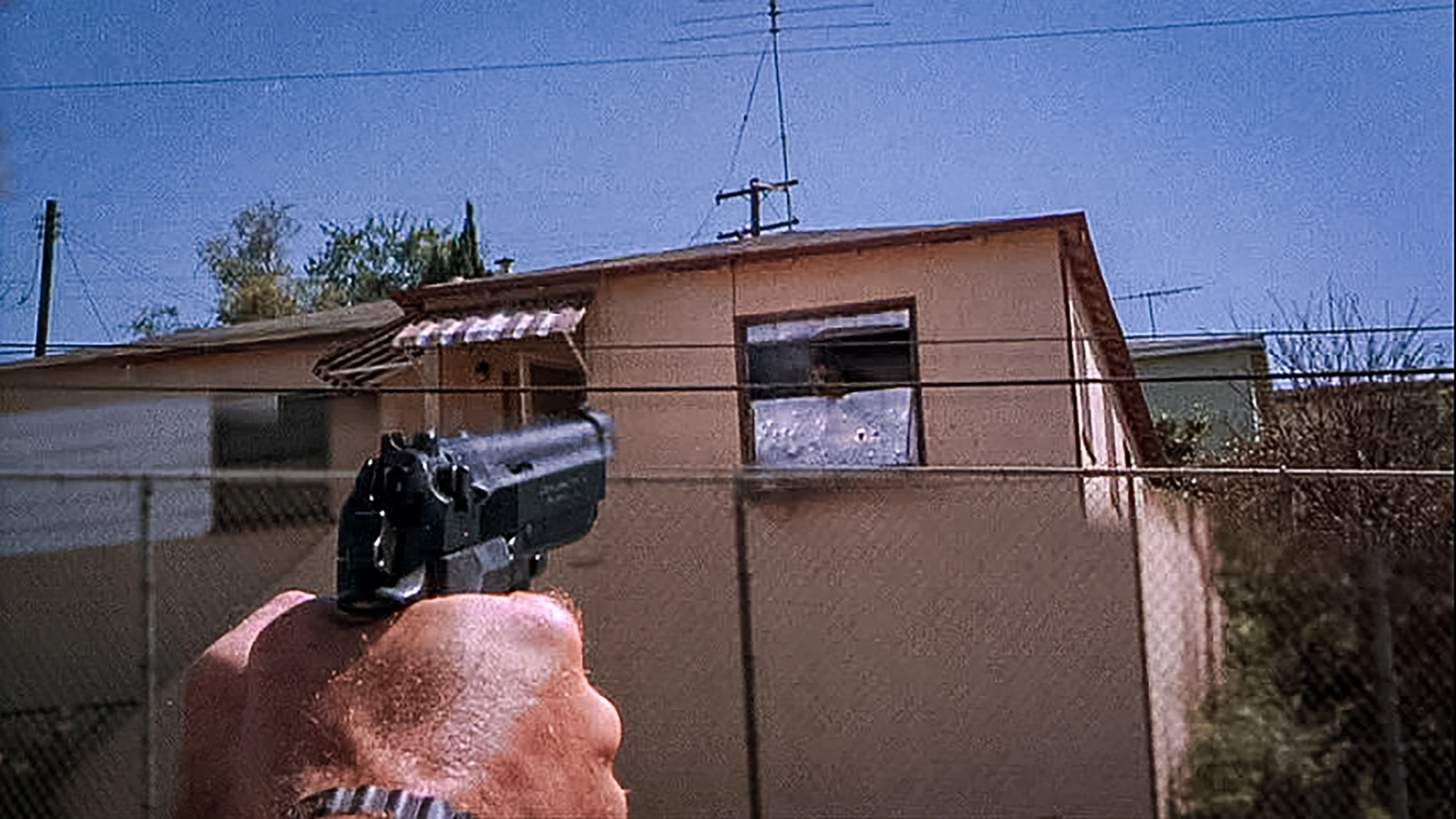 Sgt. Martin Riggs (Mel Gibson) aims his Beretta 92F pistol at a sniper's hideout.