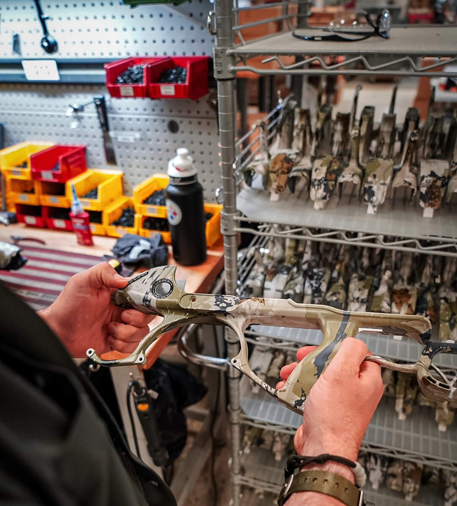 a man holding a stock of an unassembled crossbow