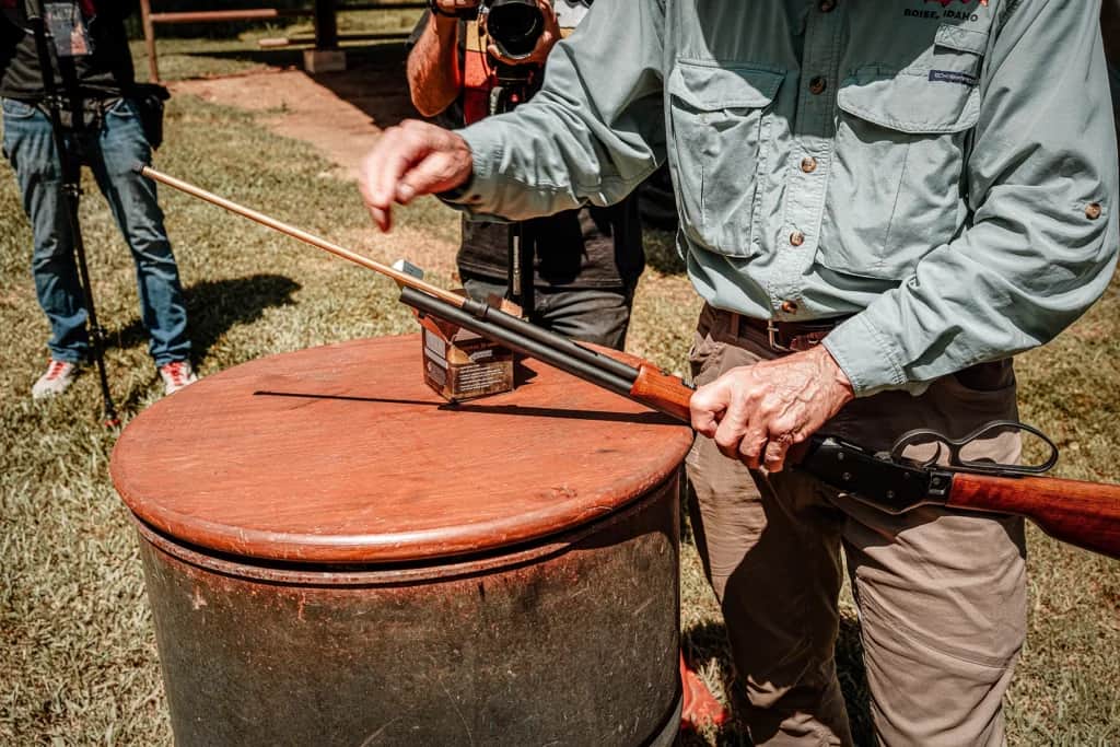 a man reloads the tubular magazine of the Savage Revel DLX at the range