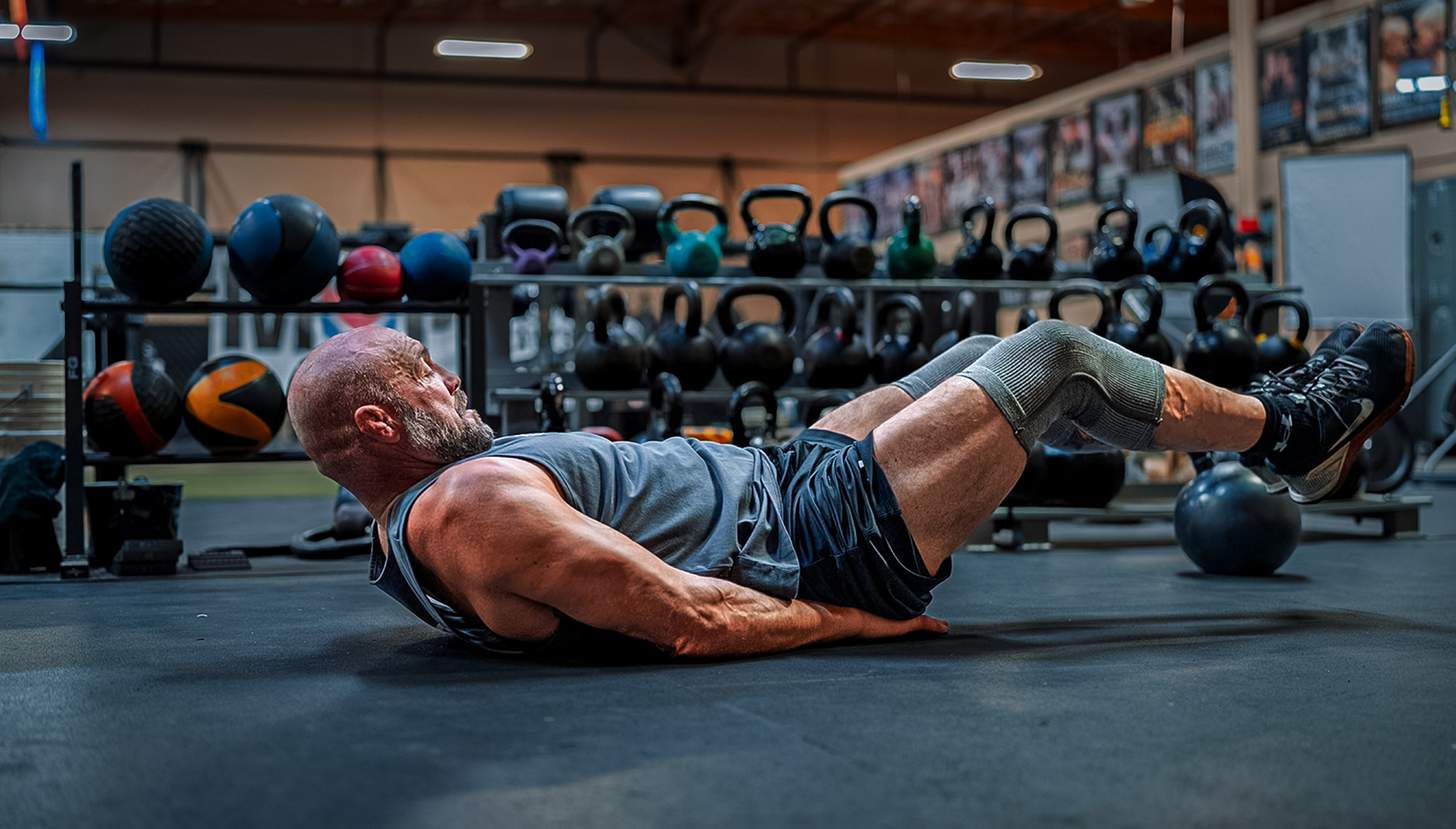 Randy Couture doing leg raises in a gym