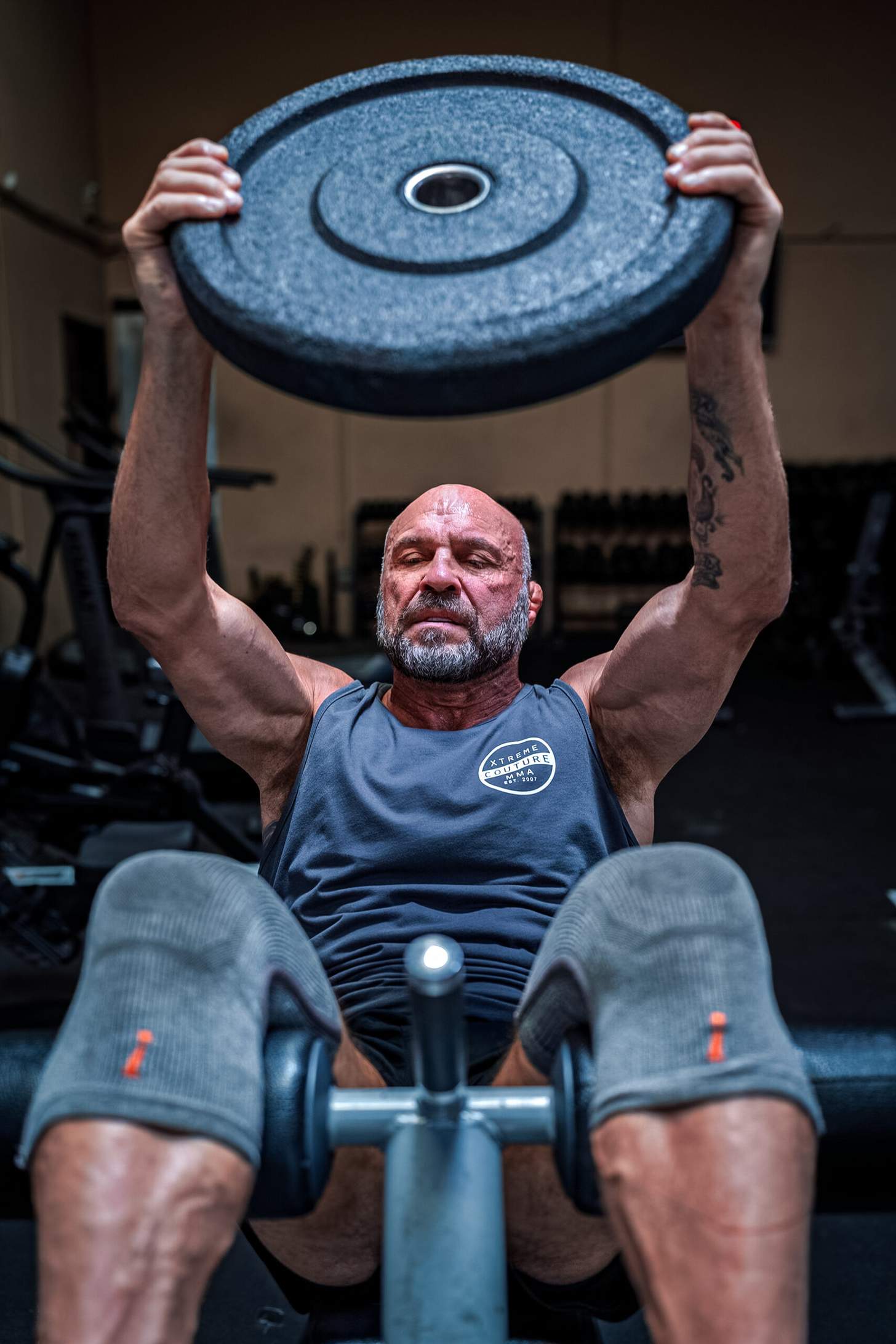 Randy Couture doing situps holdin a plate