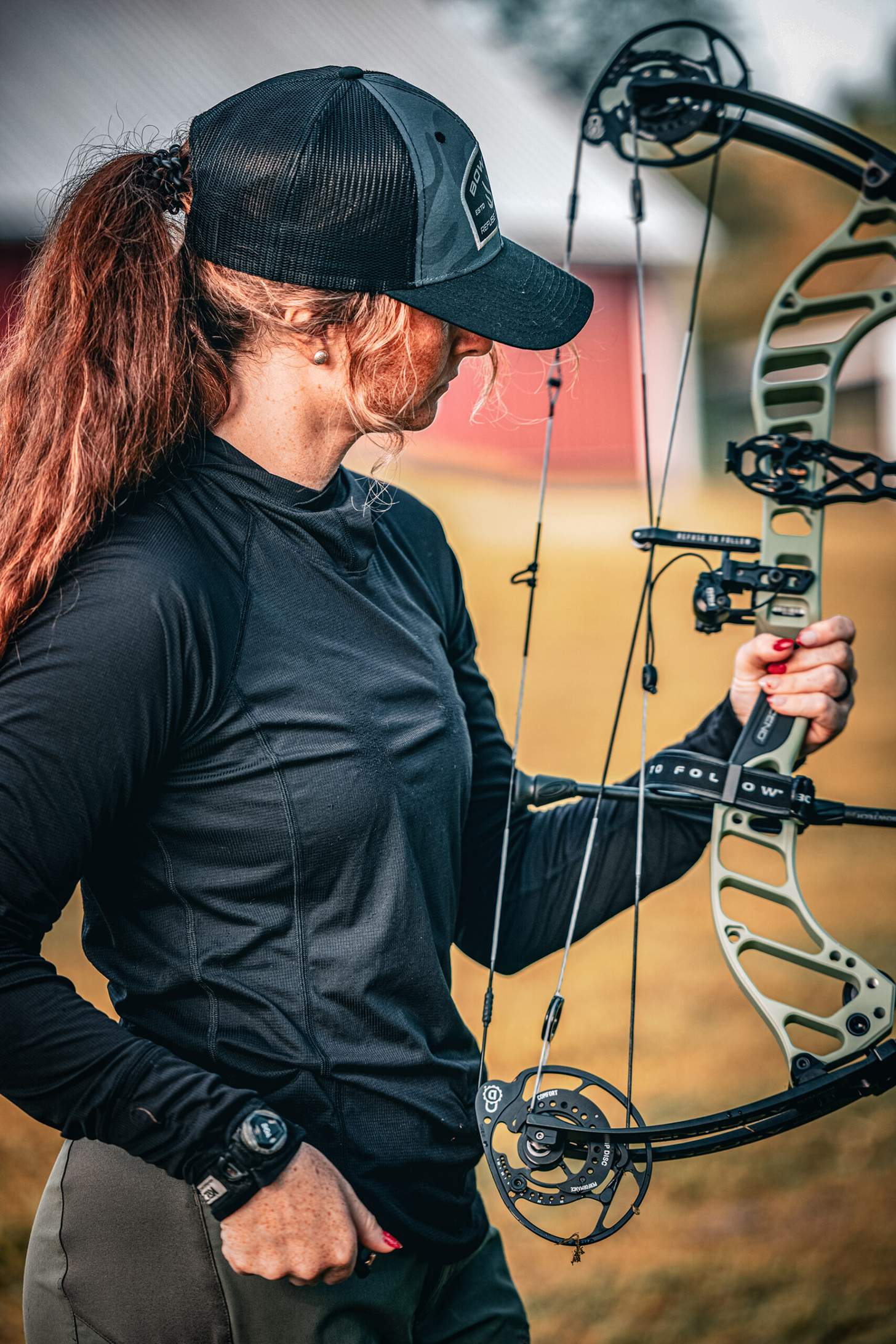 a woman archer holding the green version of the Bowtech Ascend in forest green