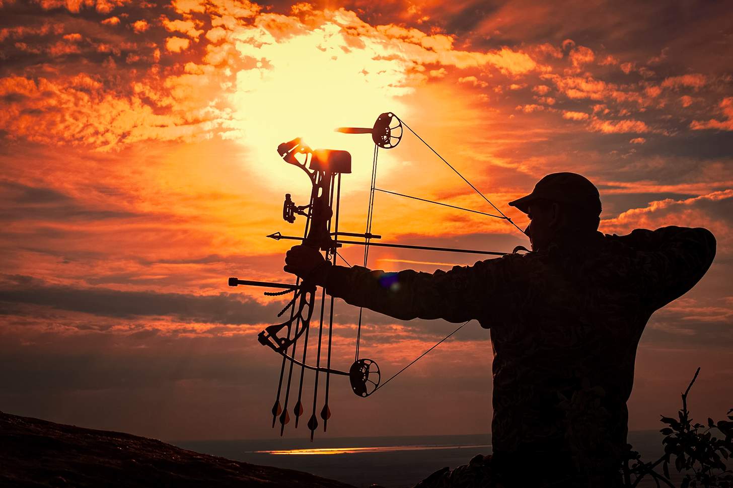 a hunter at full draw in front of the sun how to choose a compound bow