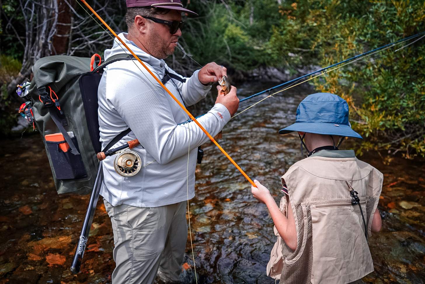 a father and son flyfishing in a stream