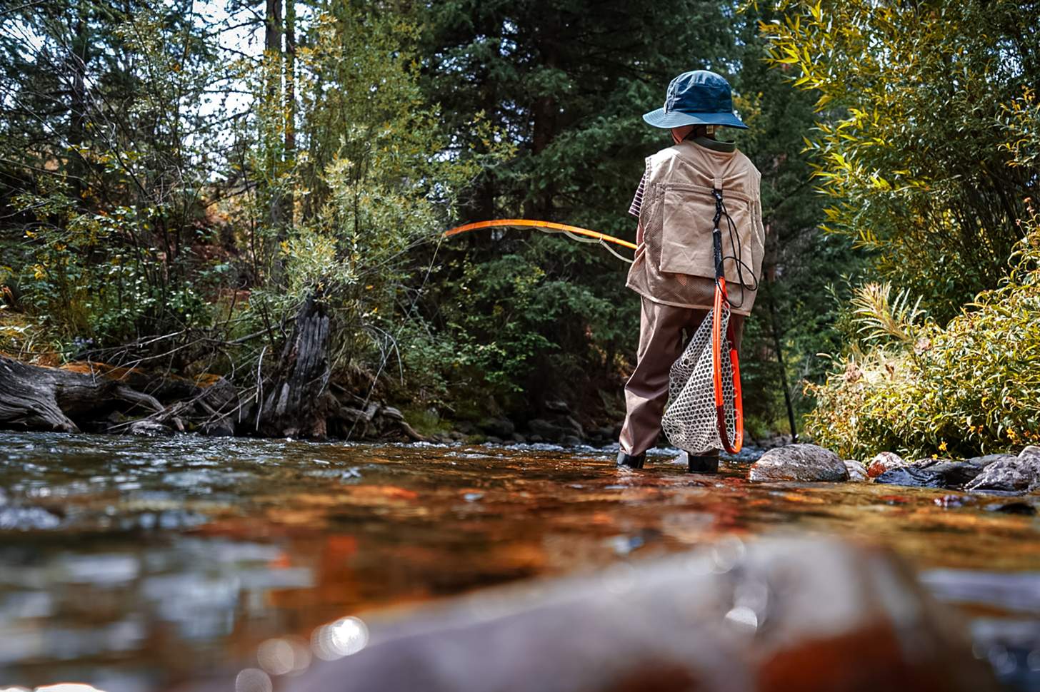 a young angler flyfishing in a stream