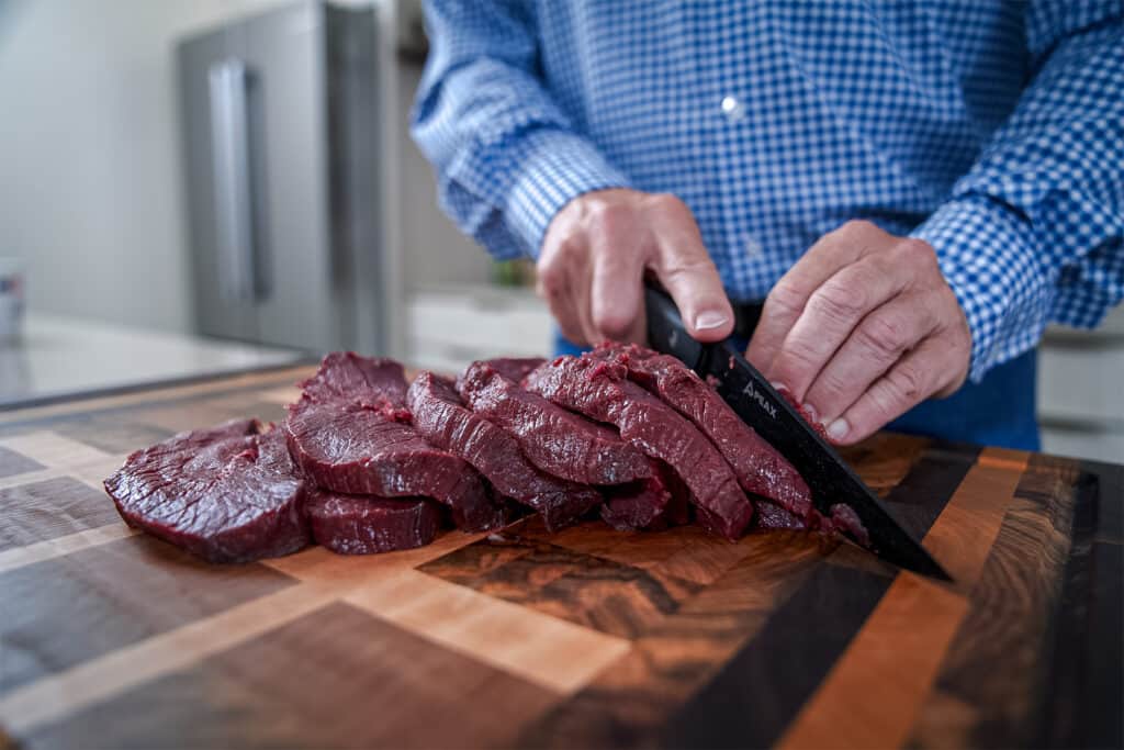 Randy Newberg cutting up caribou meat