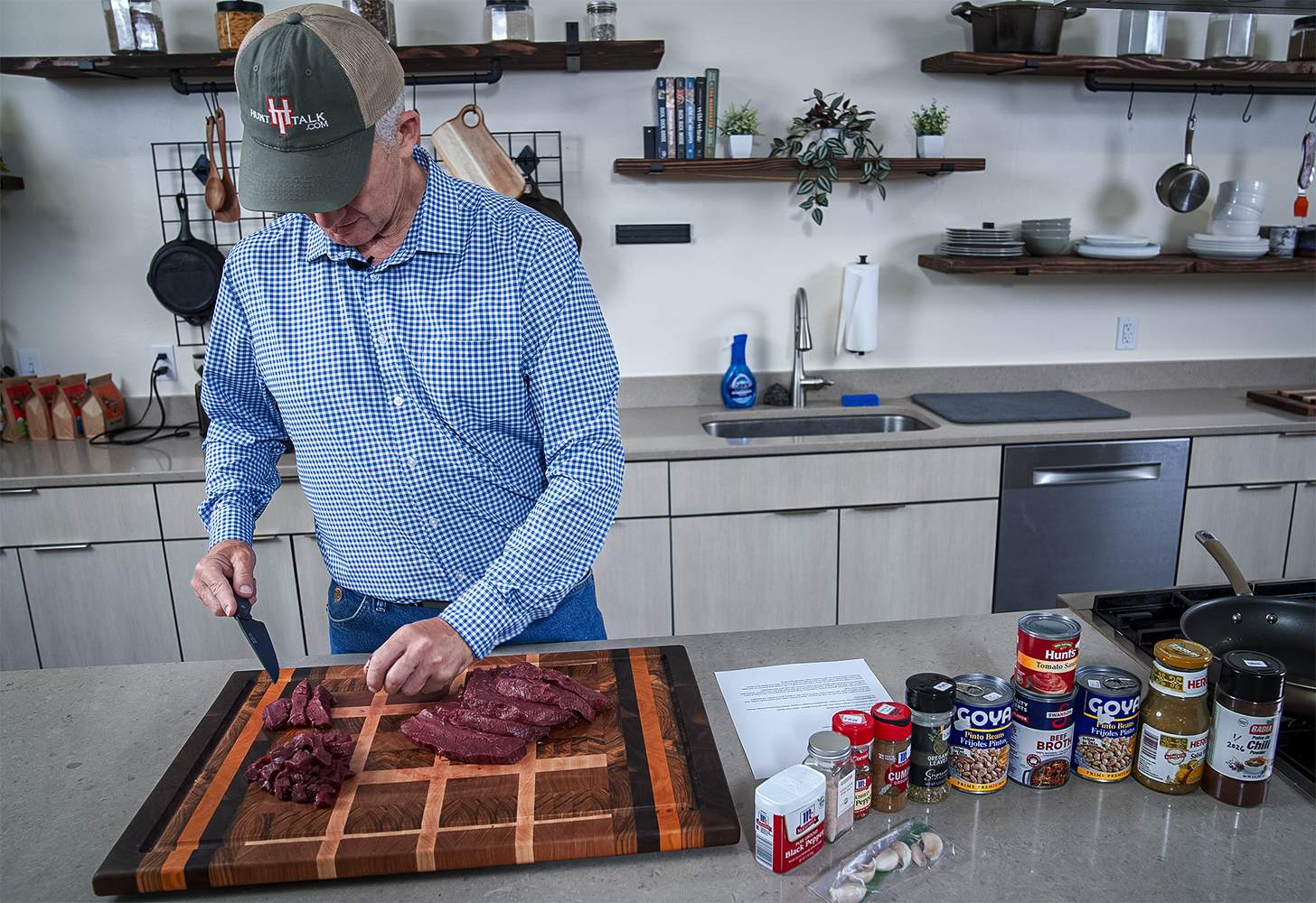 Randy Newberg cutting up caribou meat on a wood cutting board