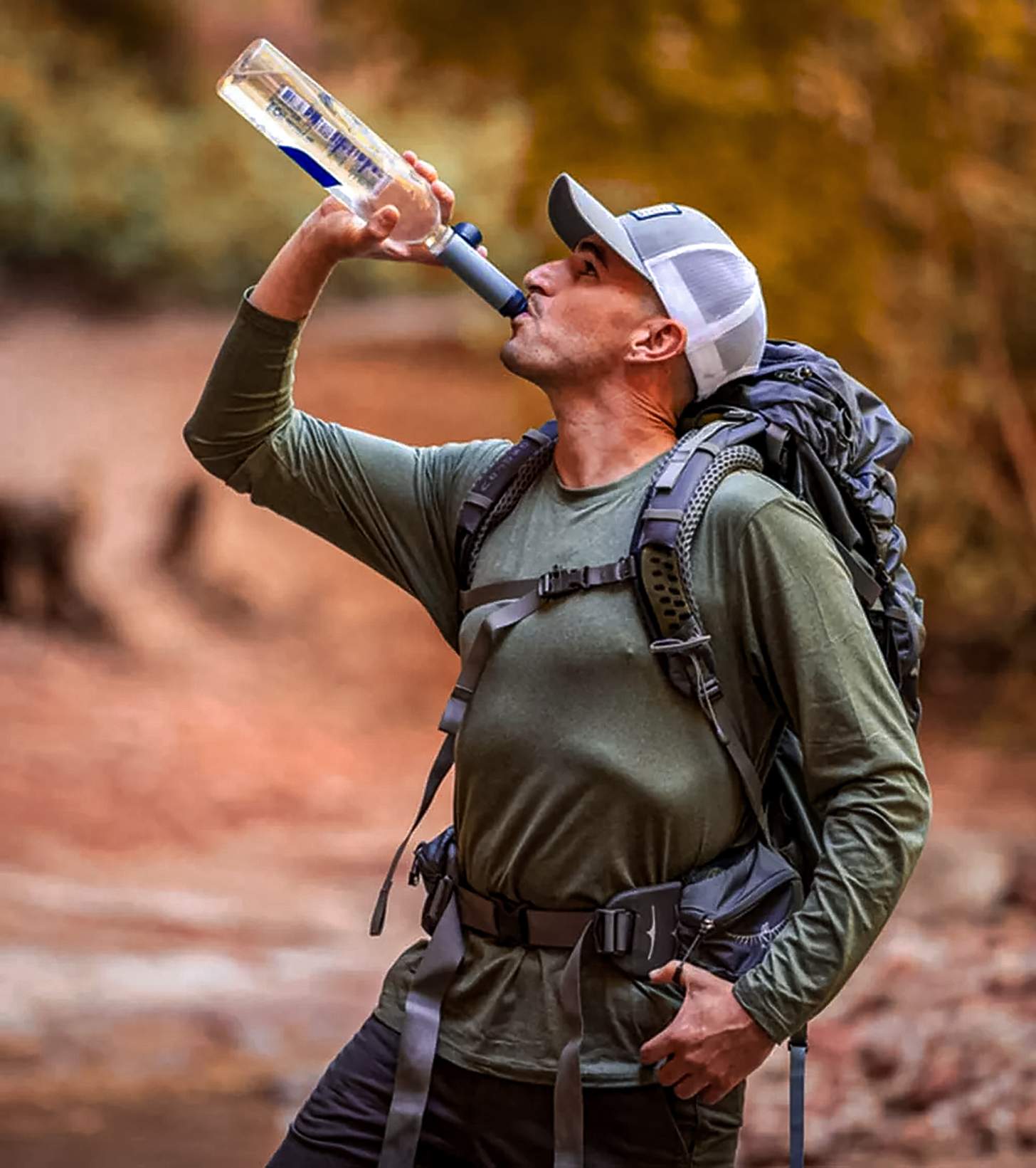 A man drinking water through a LifeStraw Solo