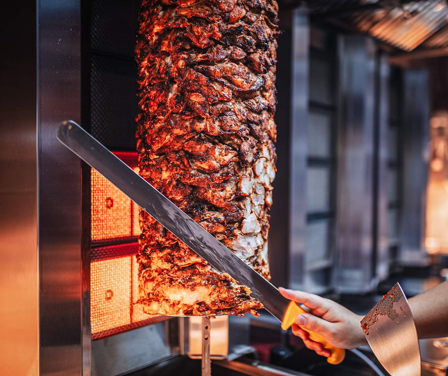 gyro meat being sliced on a spit