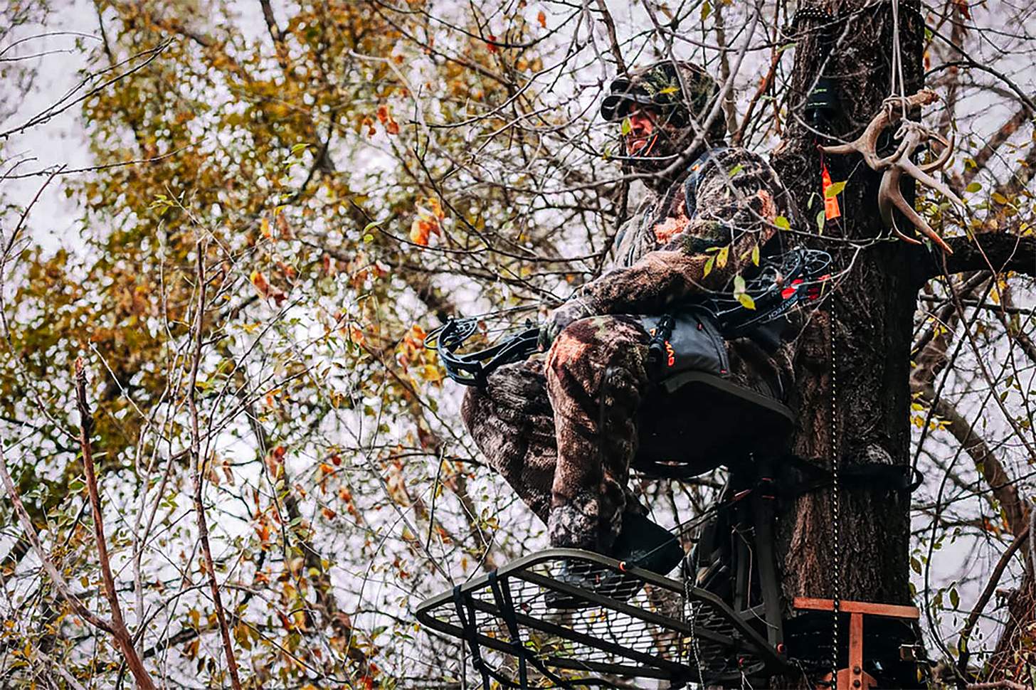 a bowhunter sitting in a treestand - early-season whitetail mistakes