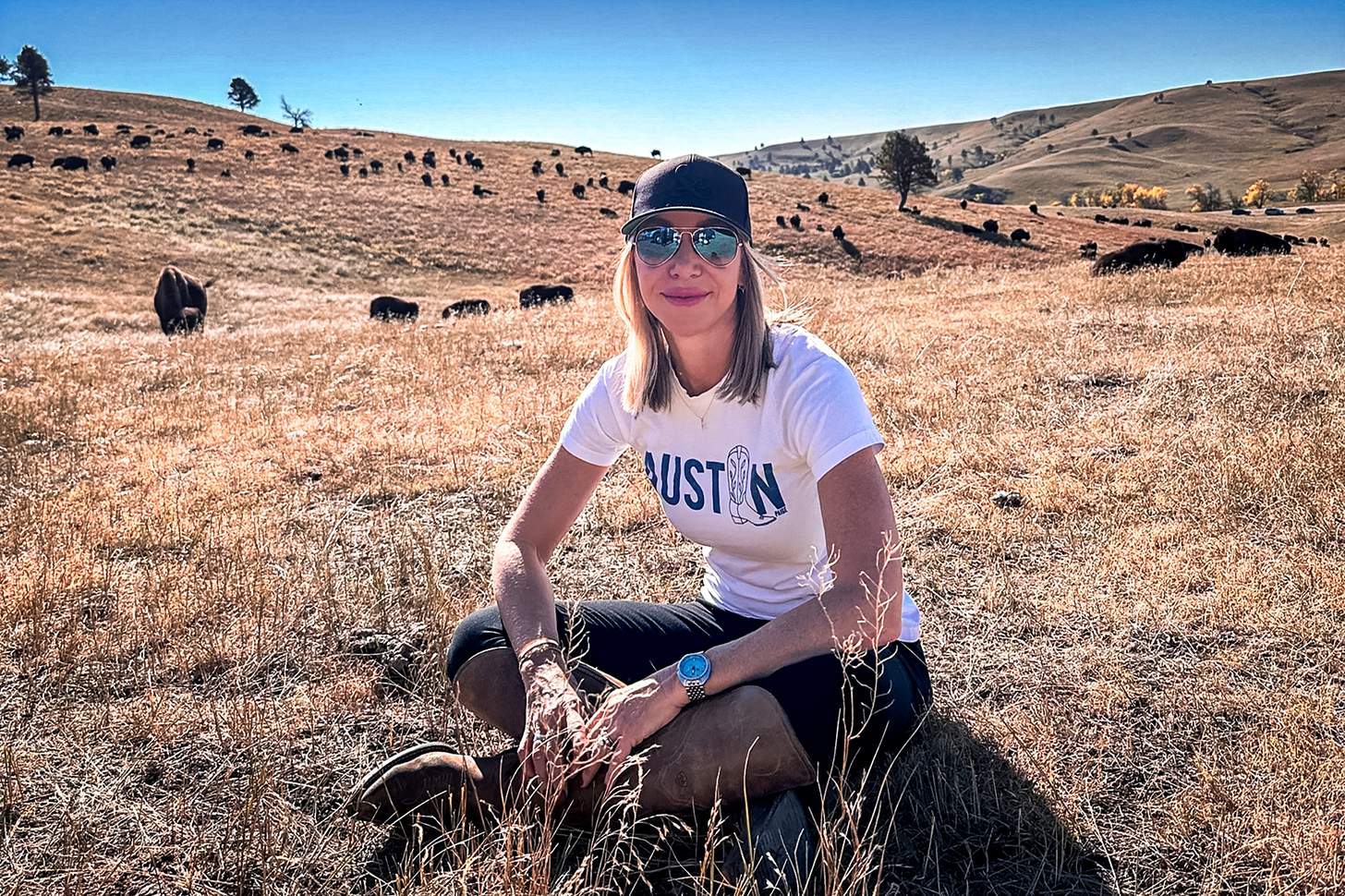 the author sitting on the plain with bison in the background