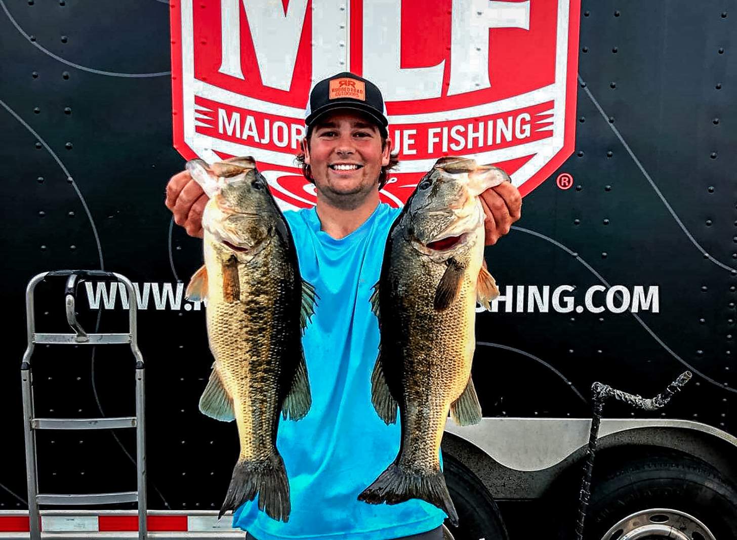 Flint Davis holding up two bass at a Major League Fishing event