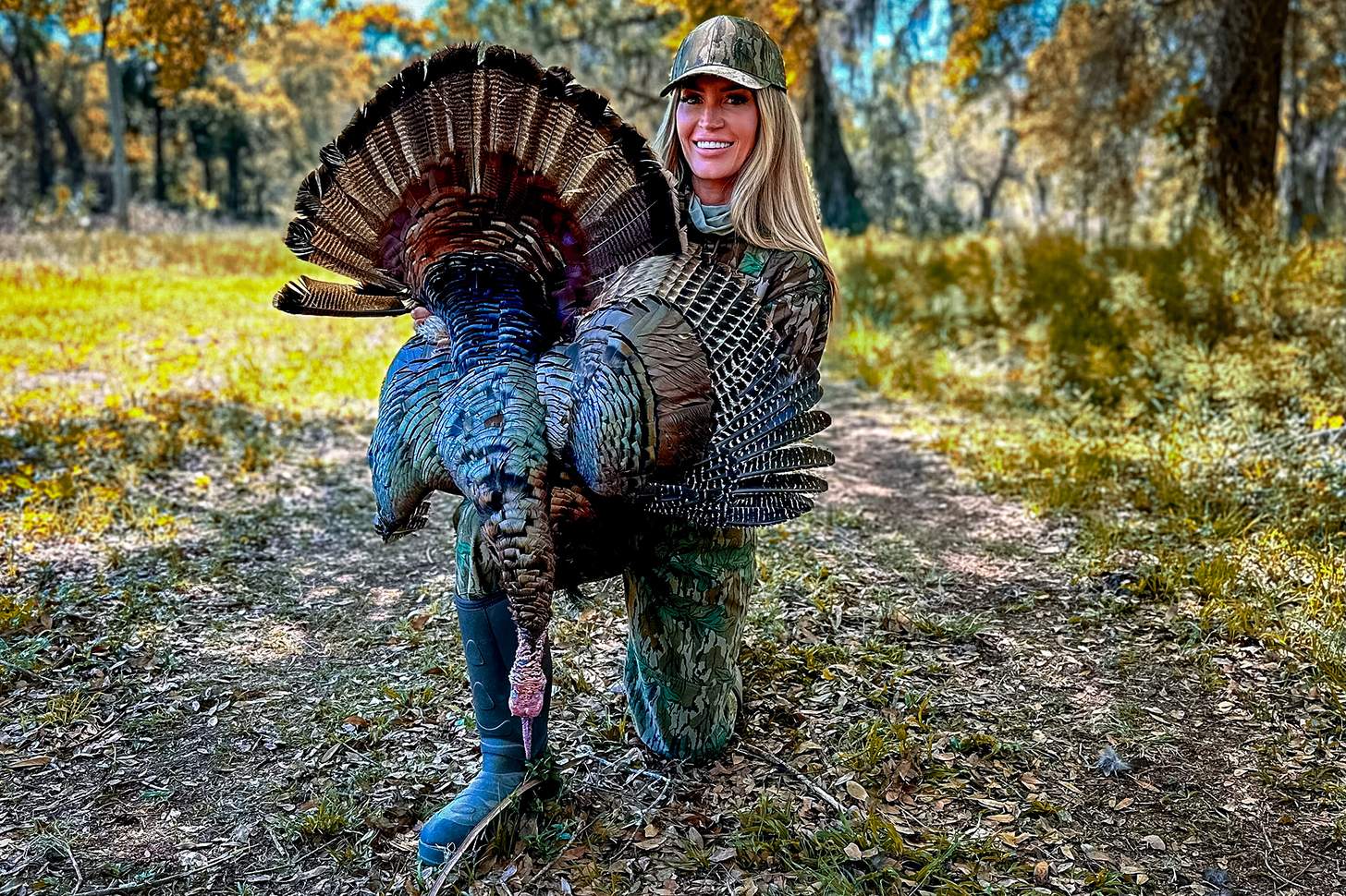 lauren brown kneeling with a wild turkey