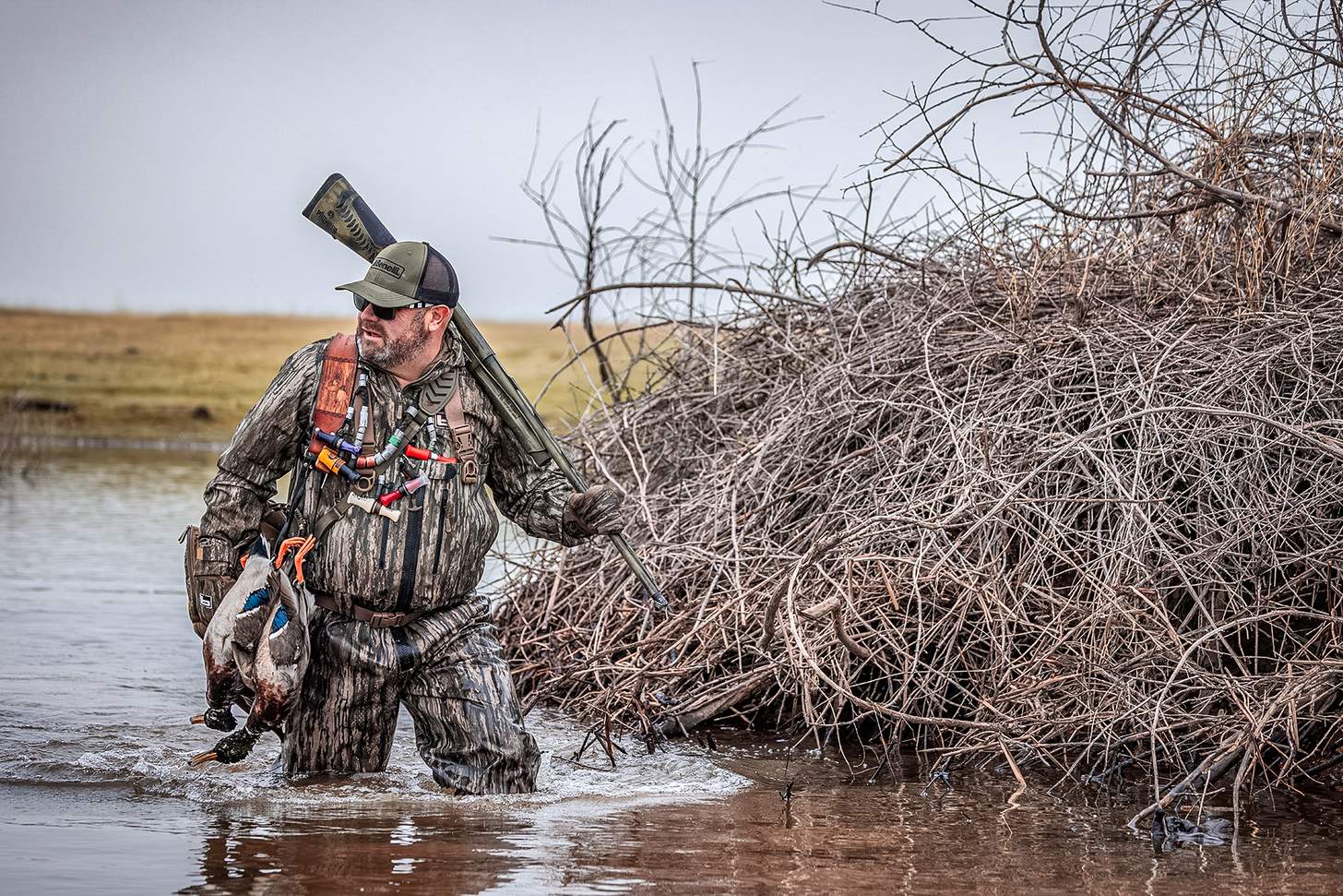 chad belding trudging through the water with mallards