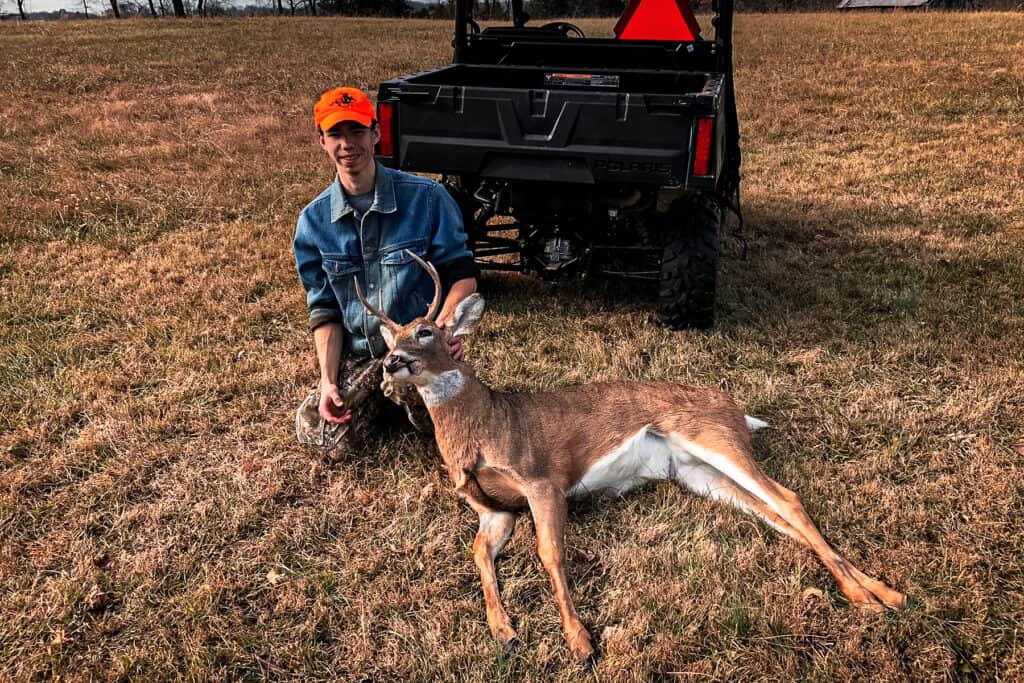 a hunter with a small whitetail buck