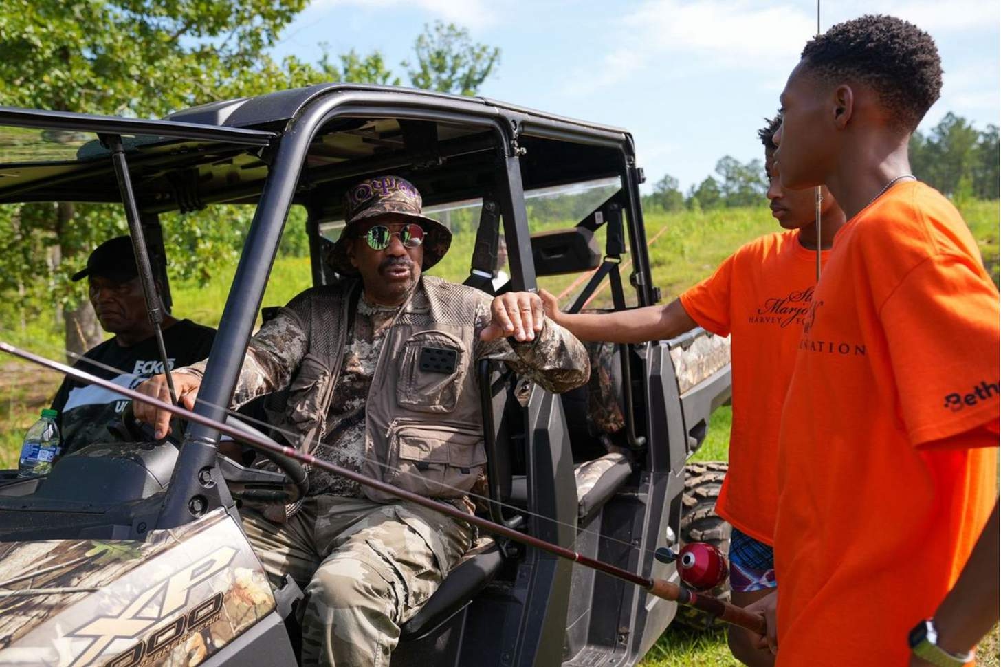 Steve Harvey rides in a side-by-side and talks to two young Anglers.