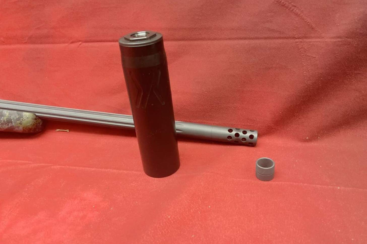 A Banish Backcountry suppressor sits on a red background.