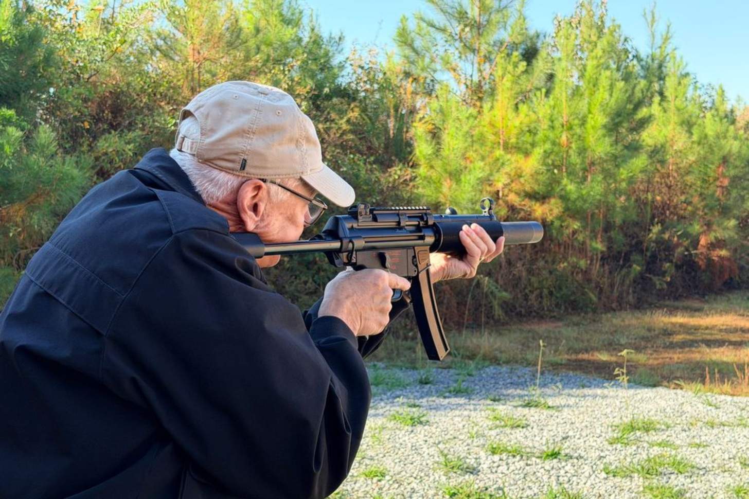 A man points a submachine gun downrange.